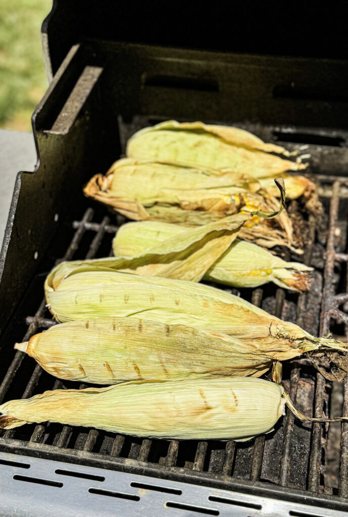 Corn in the husk on the grill.