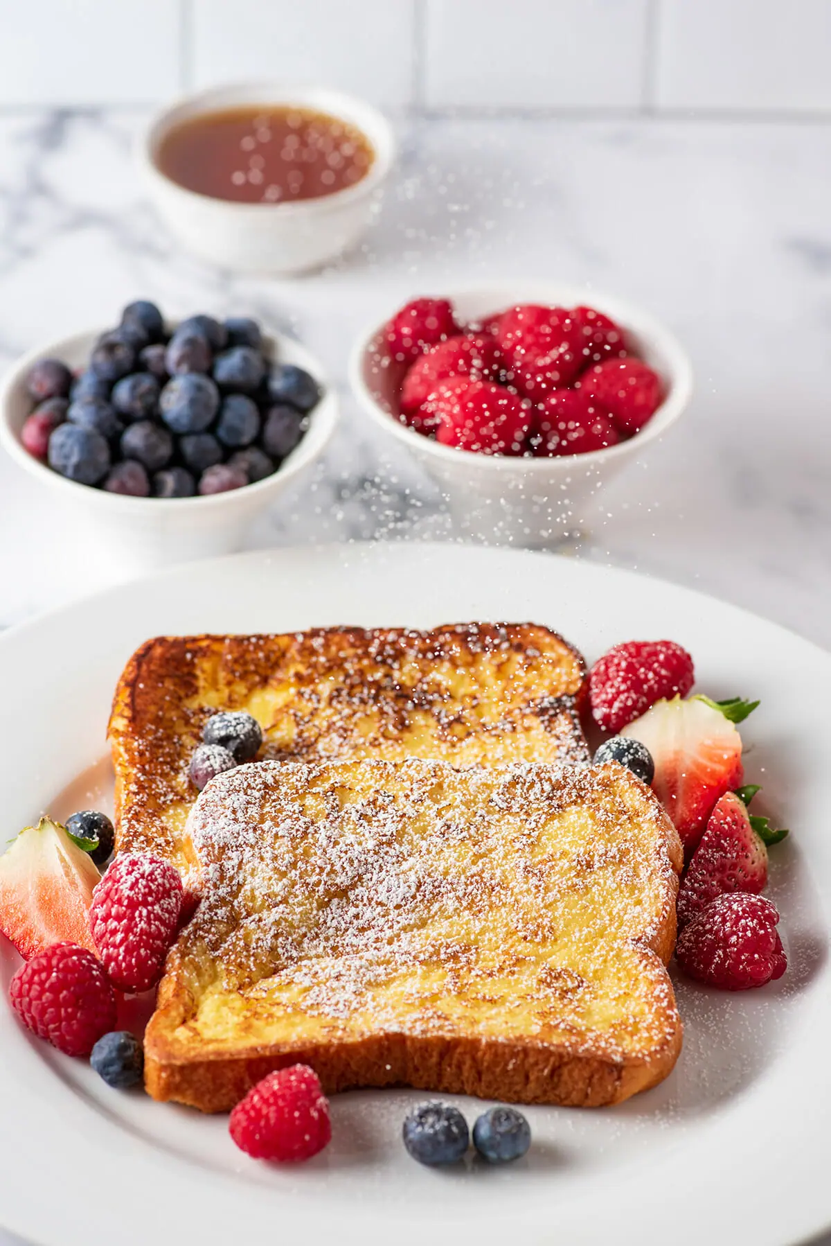 Homemade French toast with berries and powdered sugar.