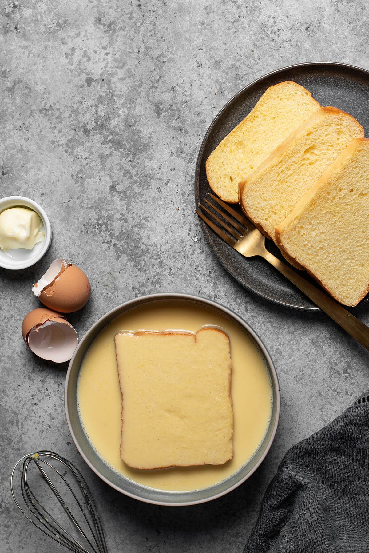 Dunking the bread into egg mixture to make French toast.