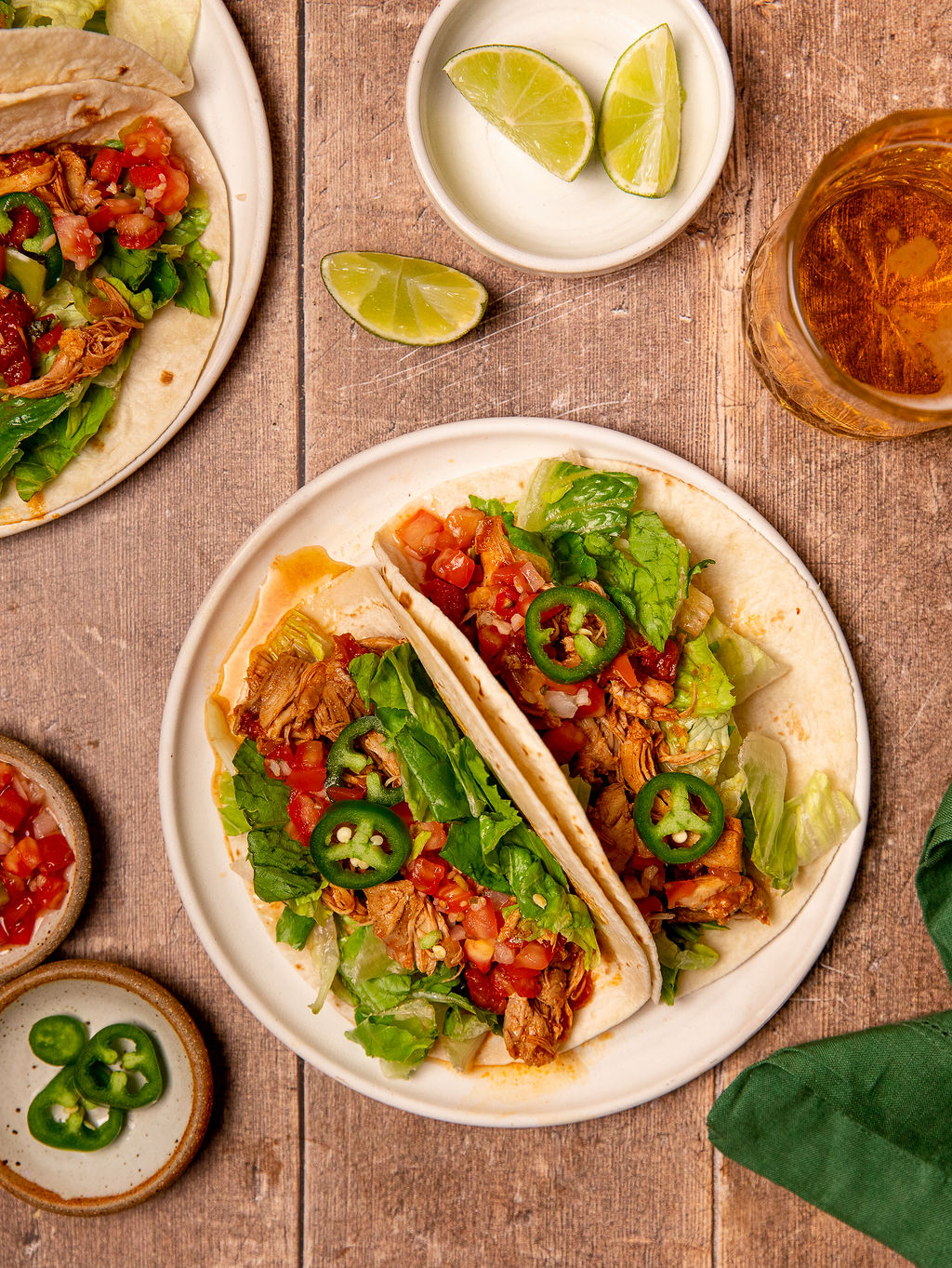 A serving of Instant Pot chicken tacos on a white plate with toppings.