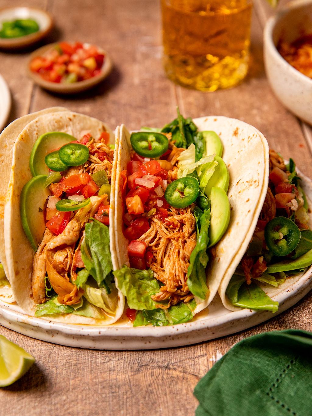 Two Instant Pot chicken tacos on a white plate loaded with toppings.