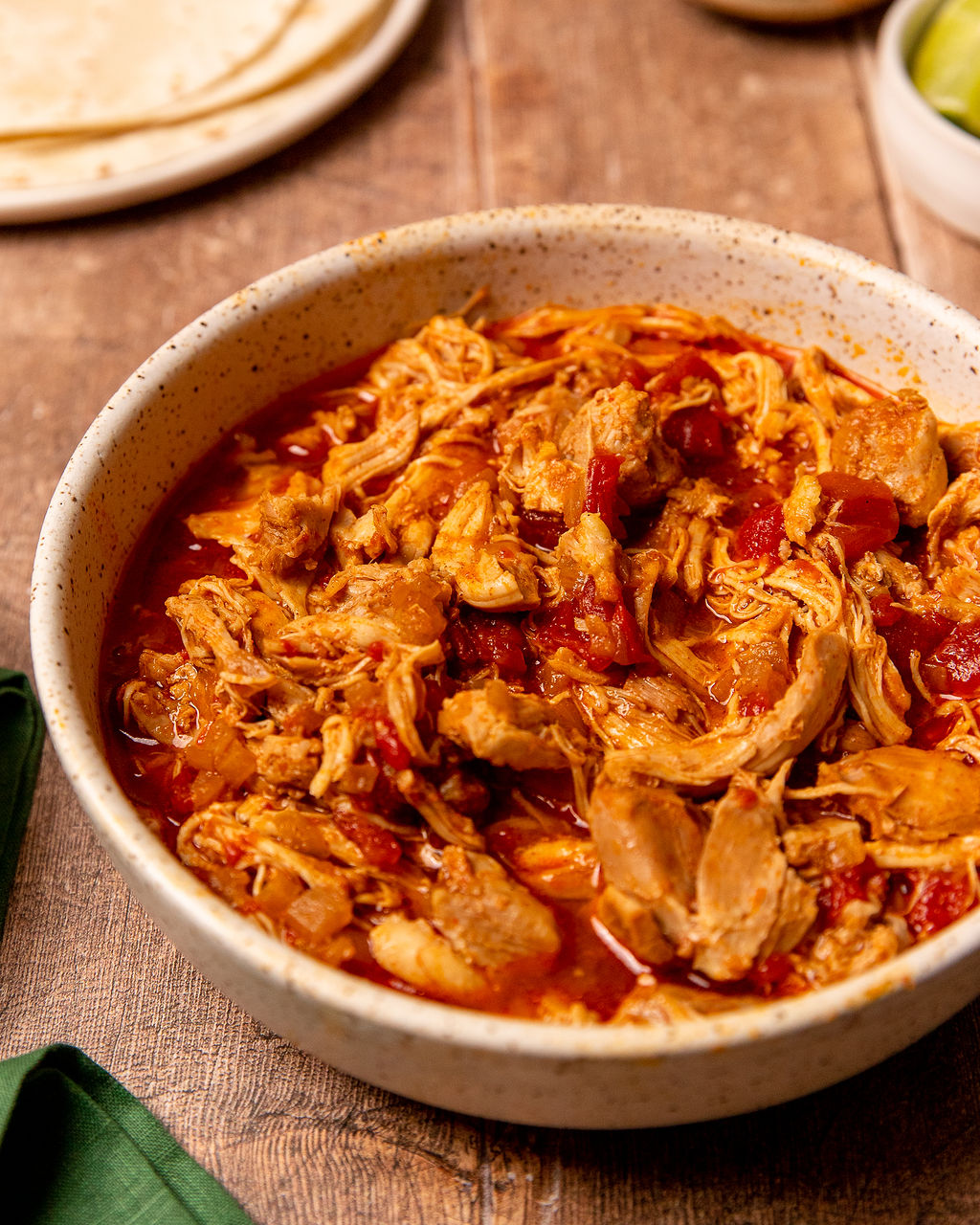 A bowl of pulled chicken coated in delicious sauce.