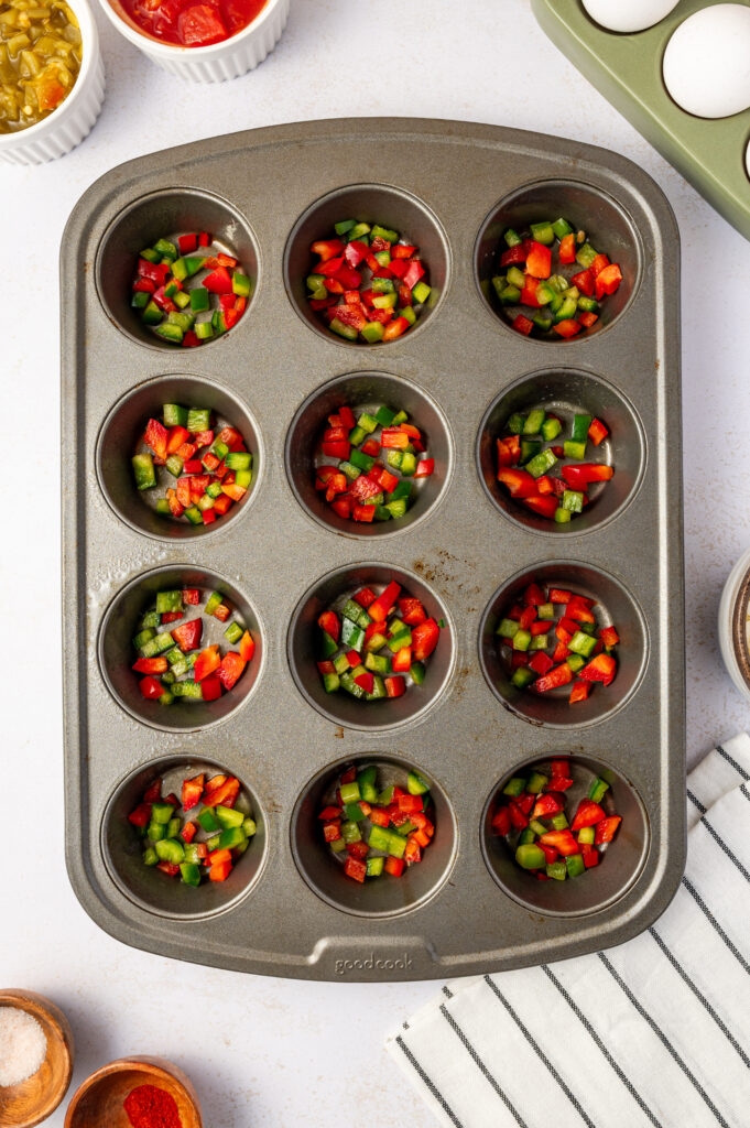 Peppers, tomatoes, and green chilies in a muffin tin.