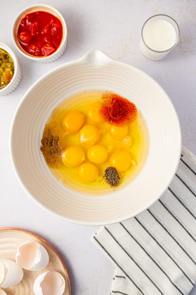 Ingredients for Southwest scrambled egg bites in a white bowl before getting mixed.