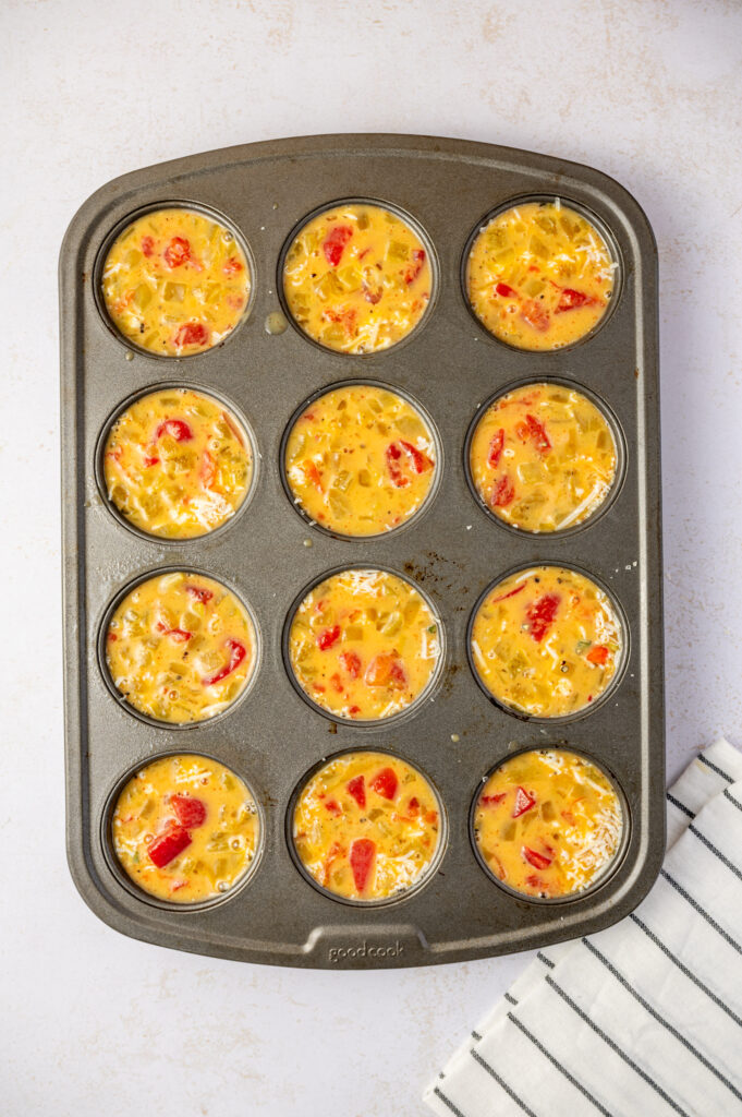 Southwest scrambled egg bites in a muffin tin before baking in the oven.