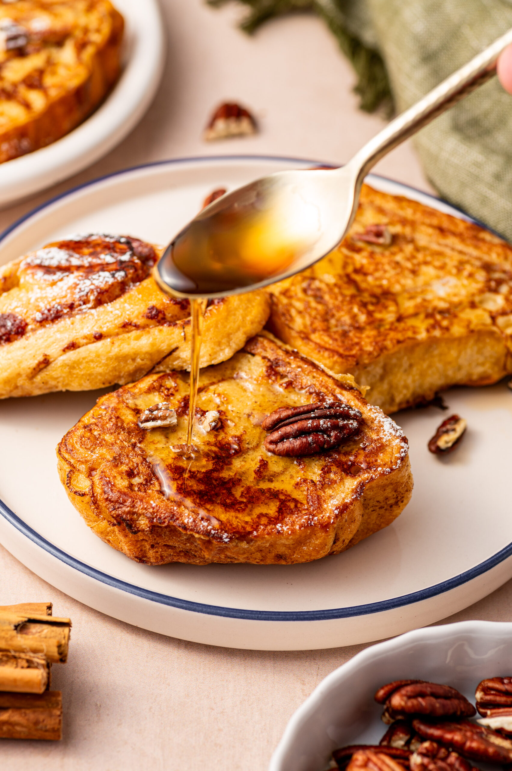 Cinnamon roll French toast with a drizzle of syrup and pecans.
