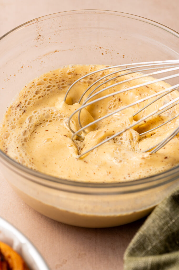 Whisking the custard in a glass bowl.