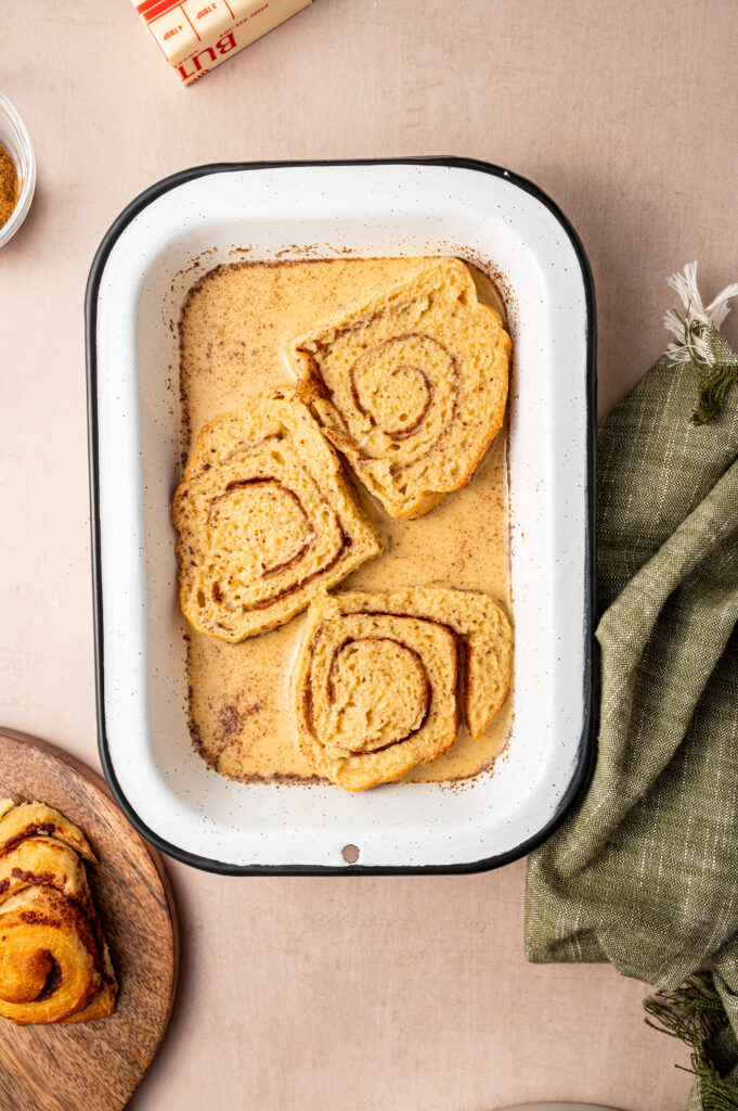 Cinnamon rolls getting dunked in custard.