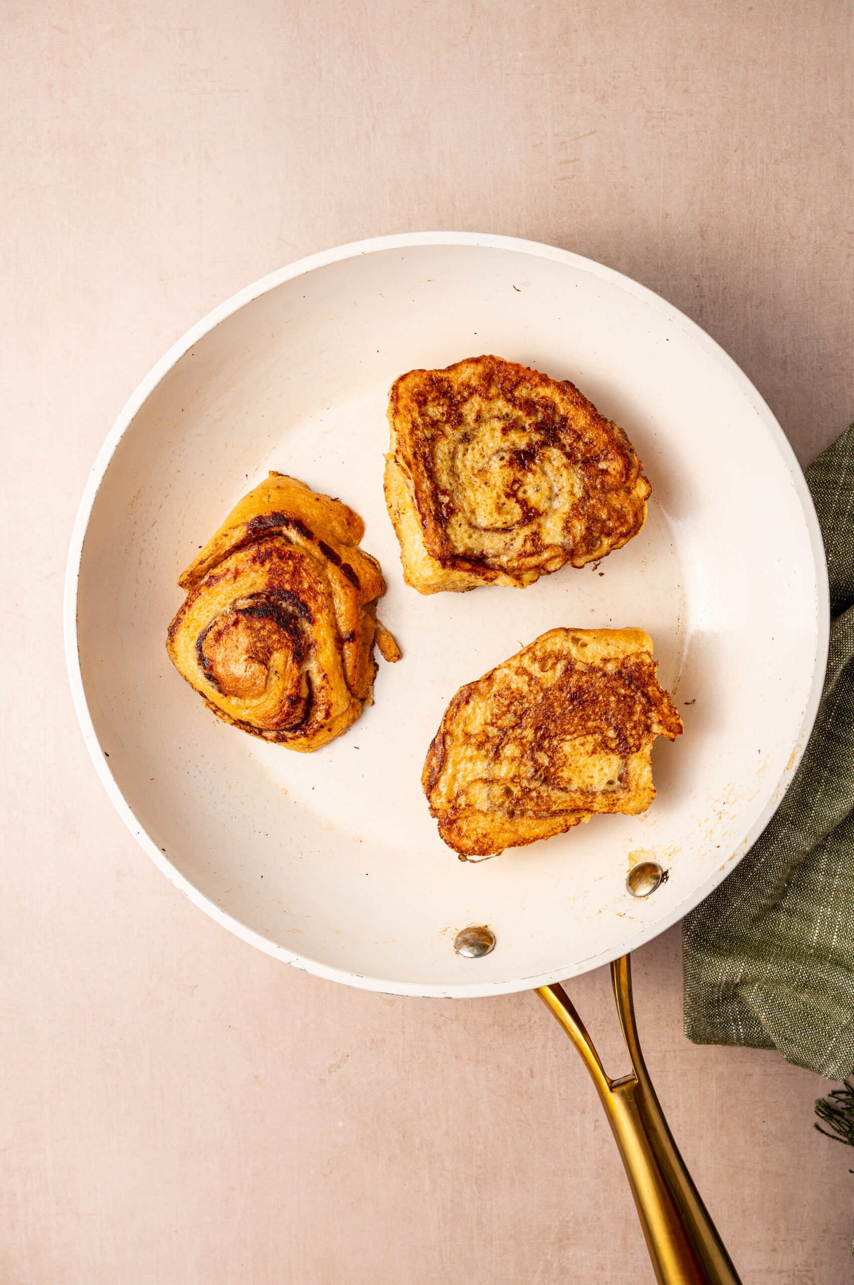 Freshly griddled cinnamon roll French toast in a skillet.
