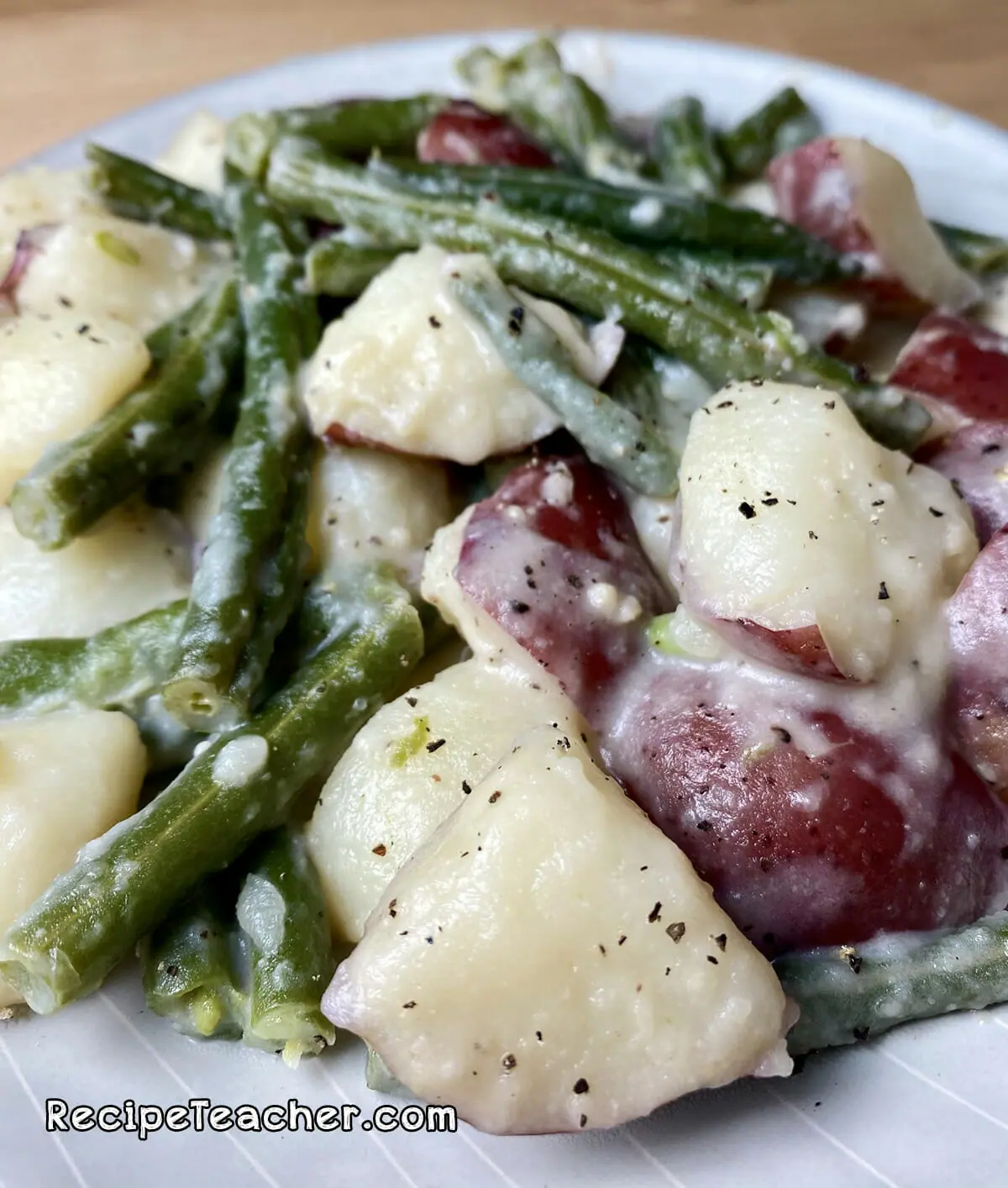 Recipe for Instant Pot potatoes and green beans in a creamy garlic Parmesan sauce.