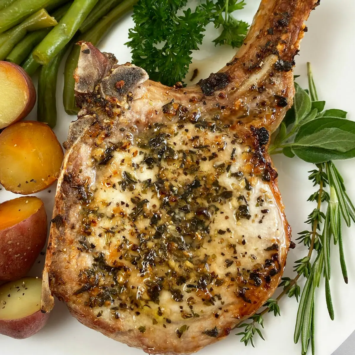 Recipe for thick and juicy, garlic and herb air fryer pork chops.