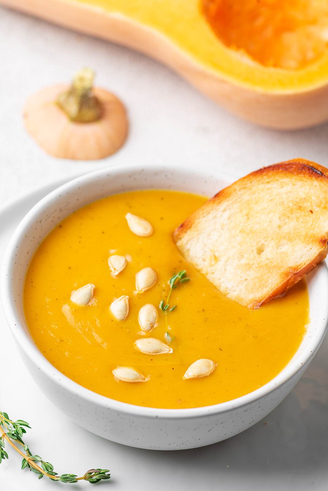 A white bowl of Instant Pot butternut squash and sweet potato soup.