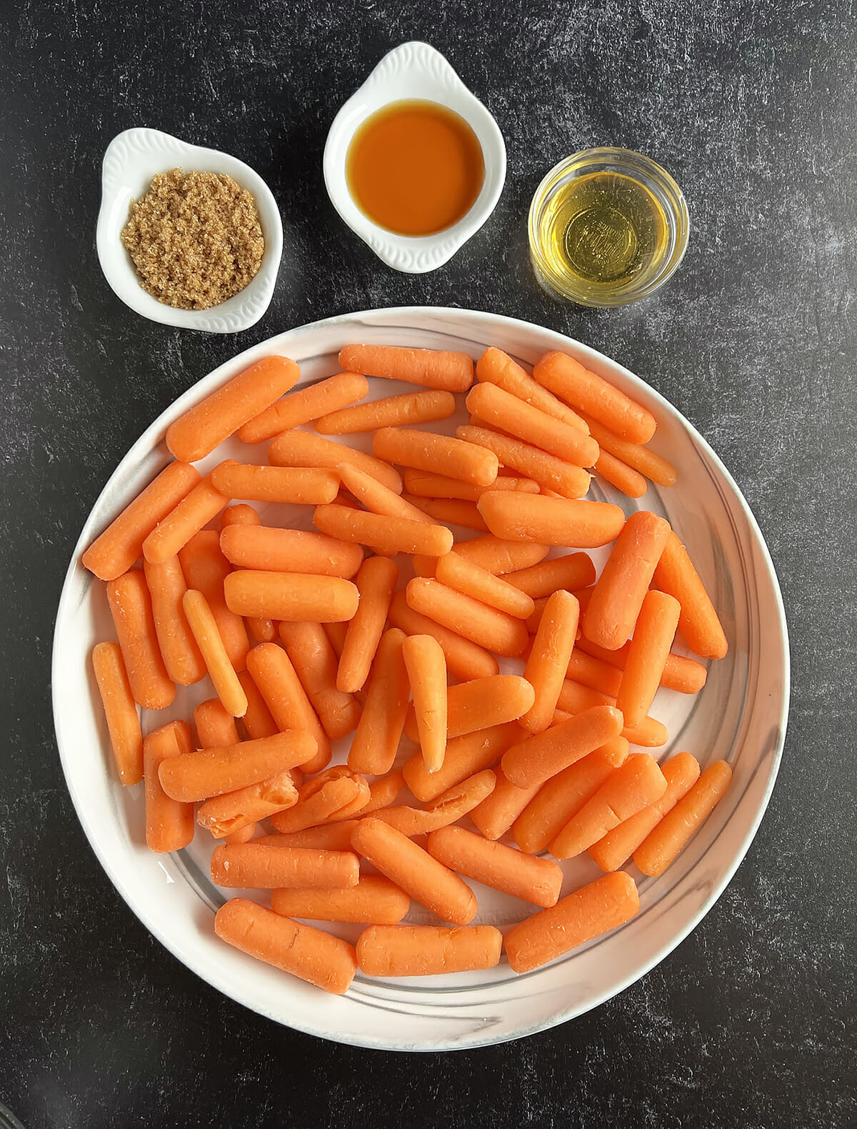 Ingredients to make air fryer honey maple roasted baby carrots