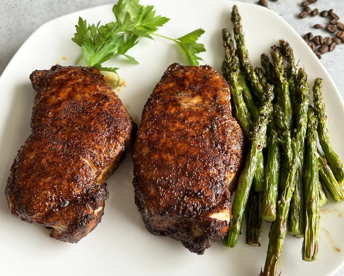 Coffee rubbed pork chops cooked in an air fryer and served with roast asparagus.