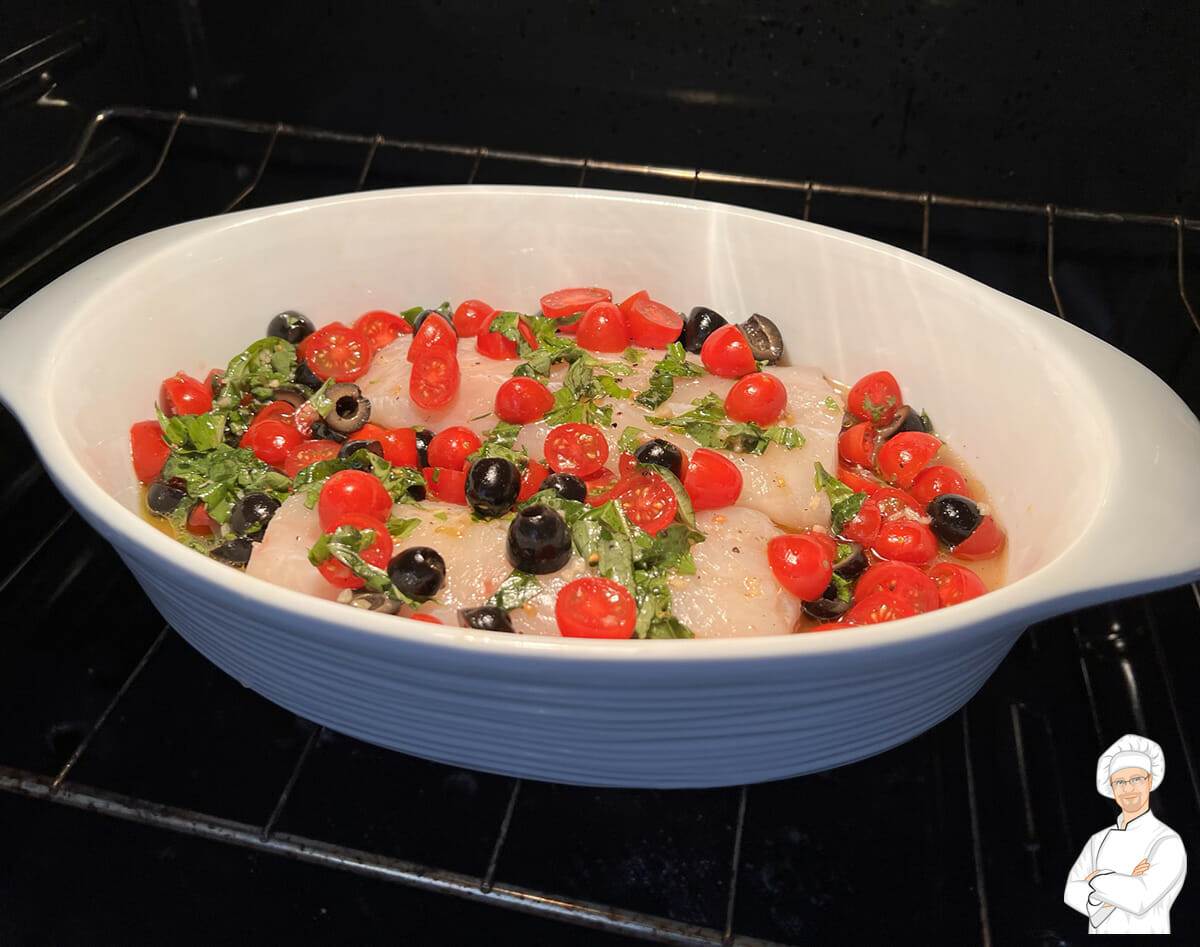 A baking dish of Mediterranean cod going into the oven.