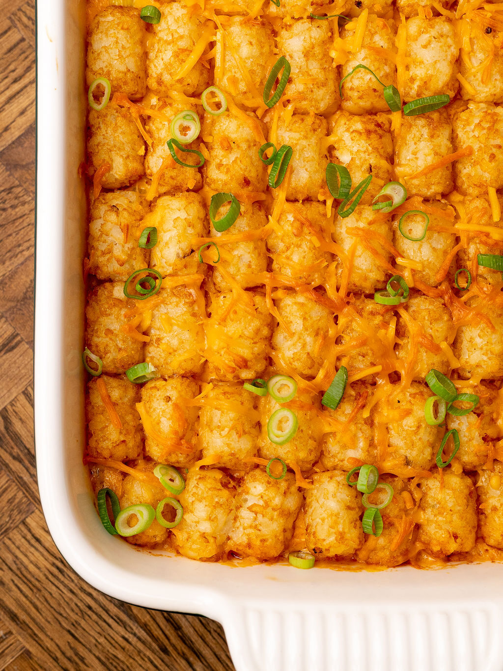 Close-up of buffalo chicken tater tot casserole in a baking dish ready to serve.