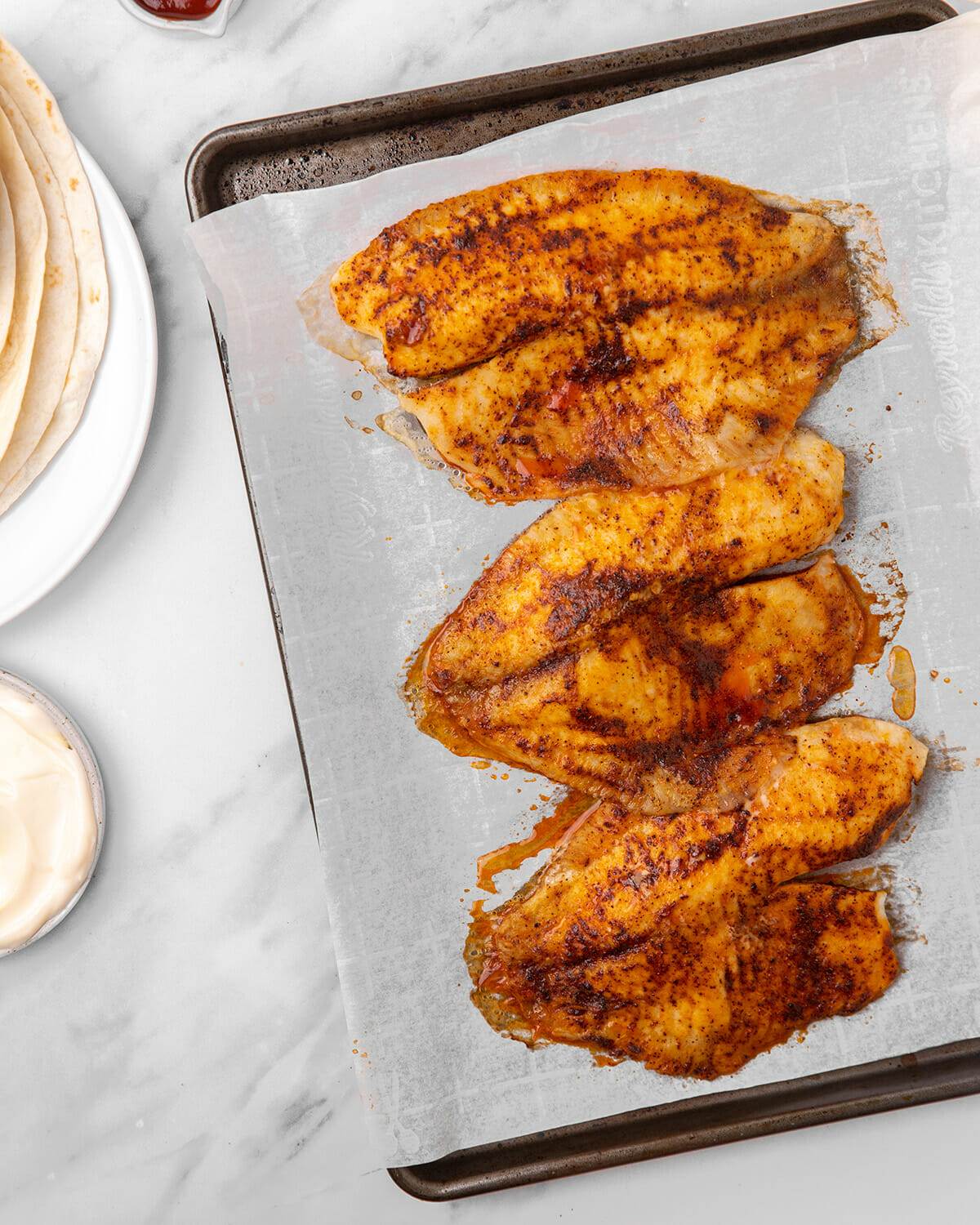 Cod filets, seasoned with Mexican seasonings and baked on a sheet pan.