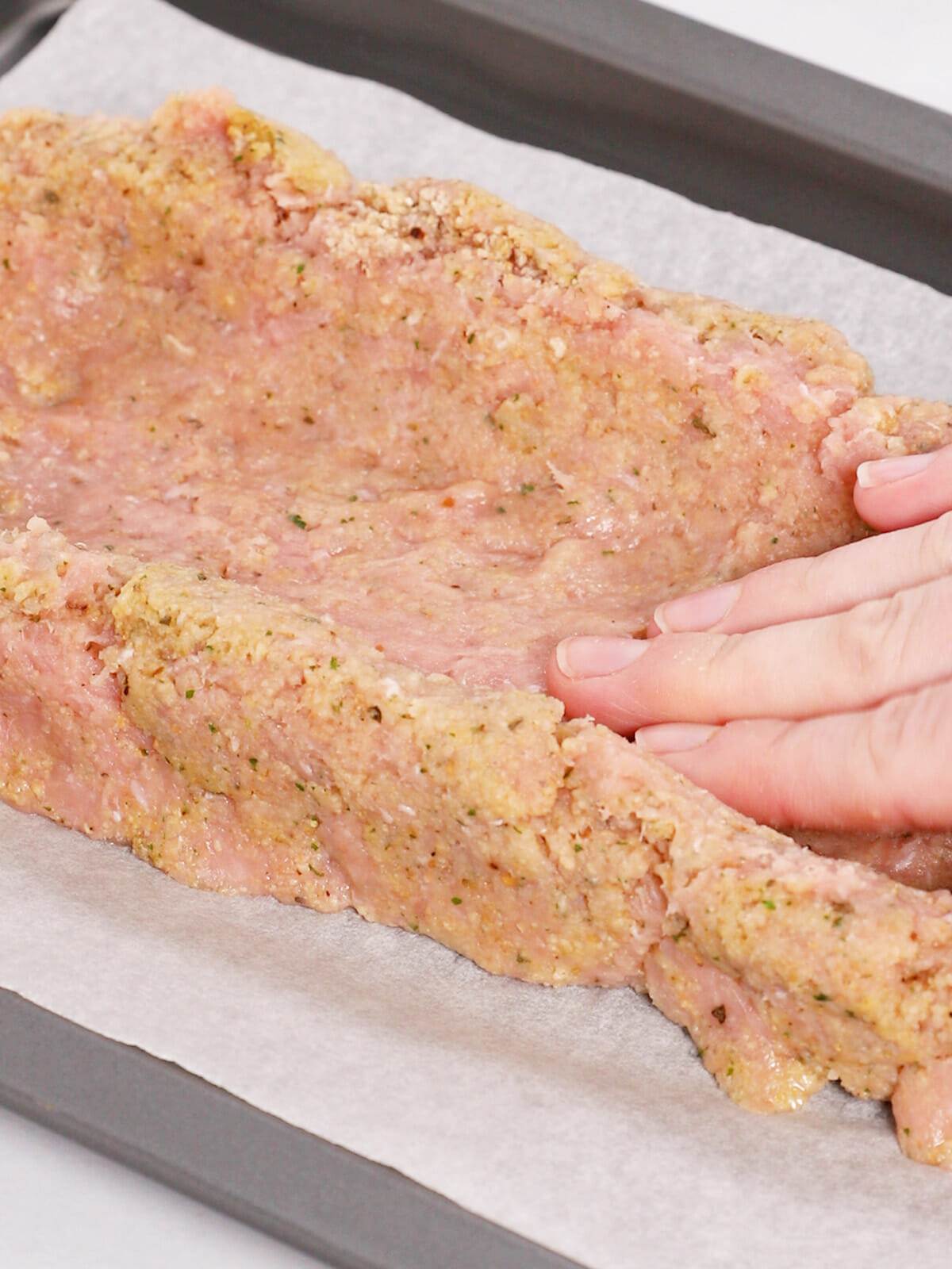 Creating the indentation to add the spinach and mozzarella cheese for our stuffed turkey meatloaf recipe.