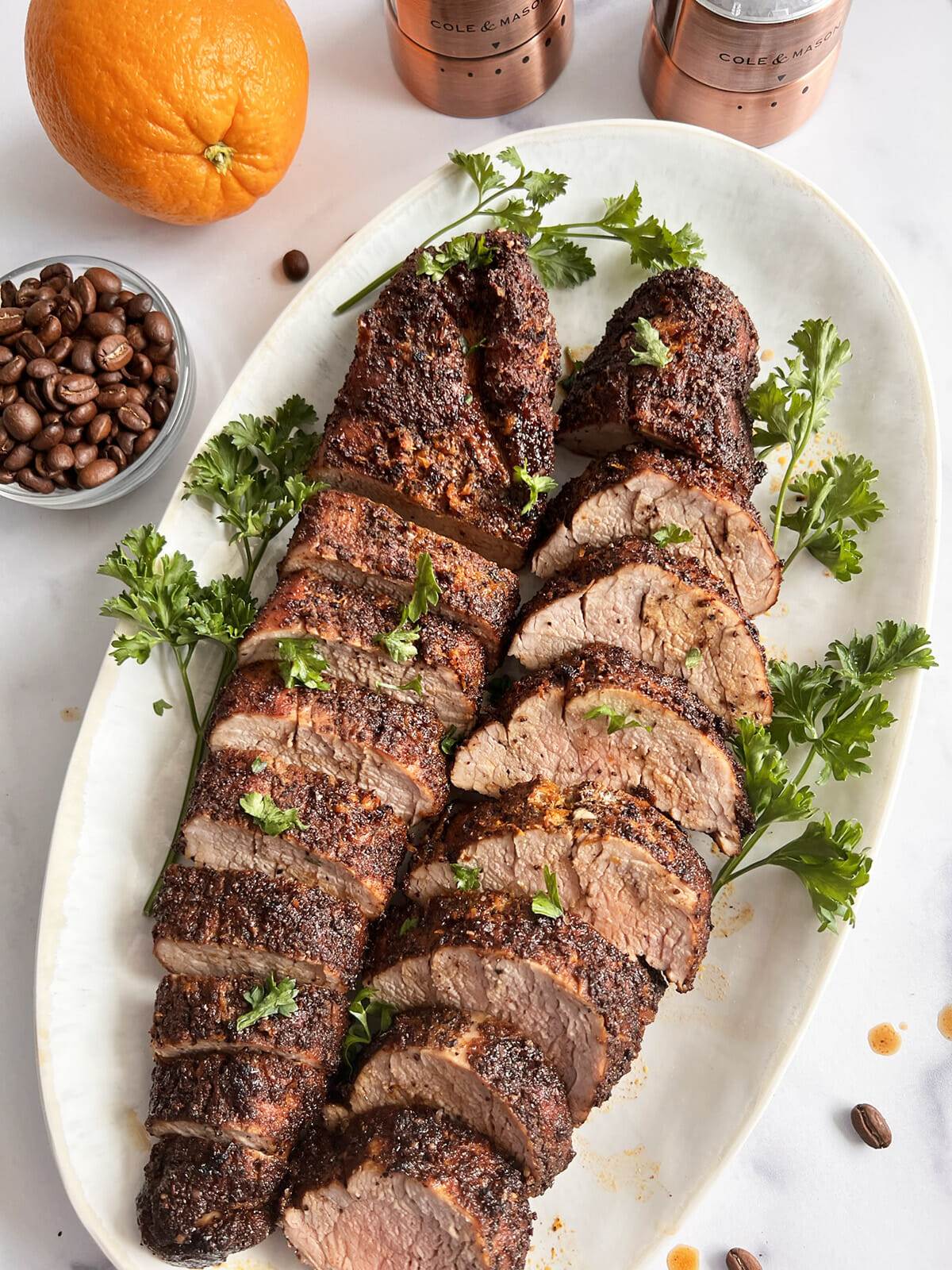 A platter with sliced pork tenderloin which was cooked in an air fryer and seasoned with a coffee citrus rub.