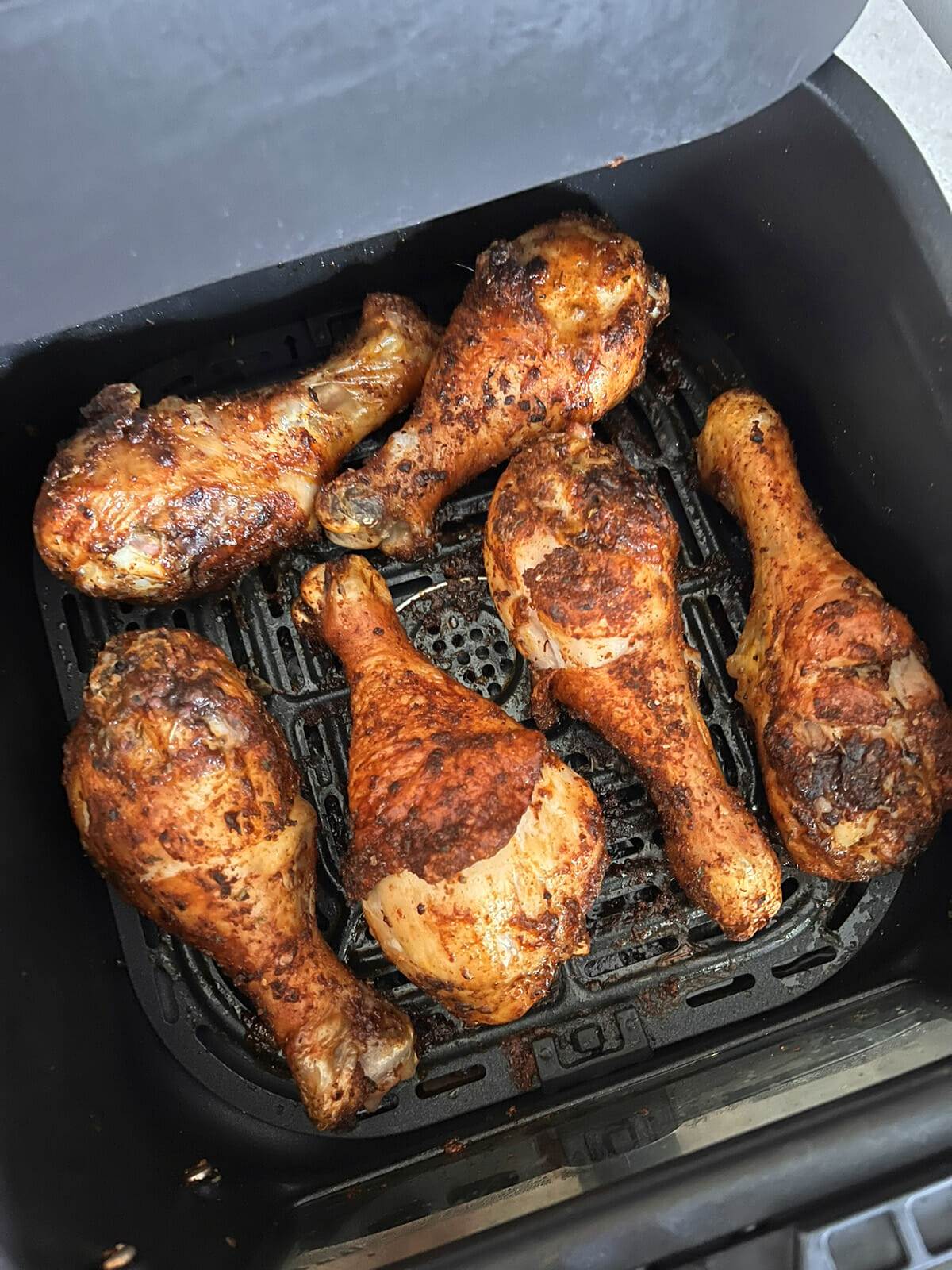 Blackened chicken drumsticks cooked in an air fryer.