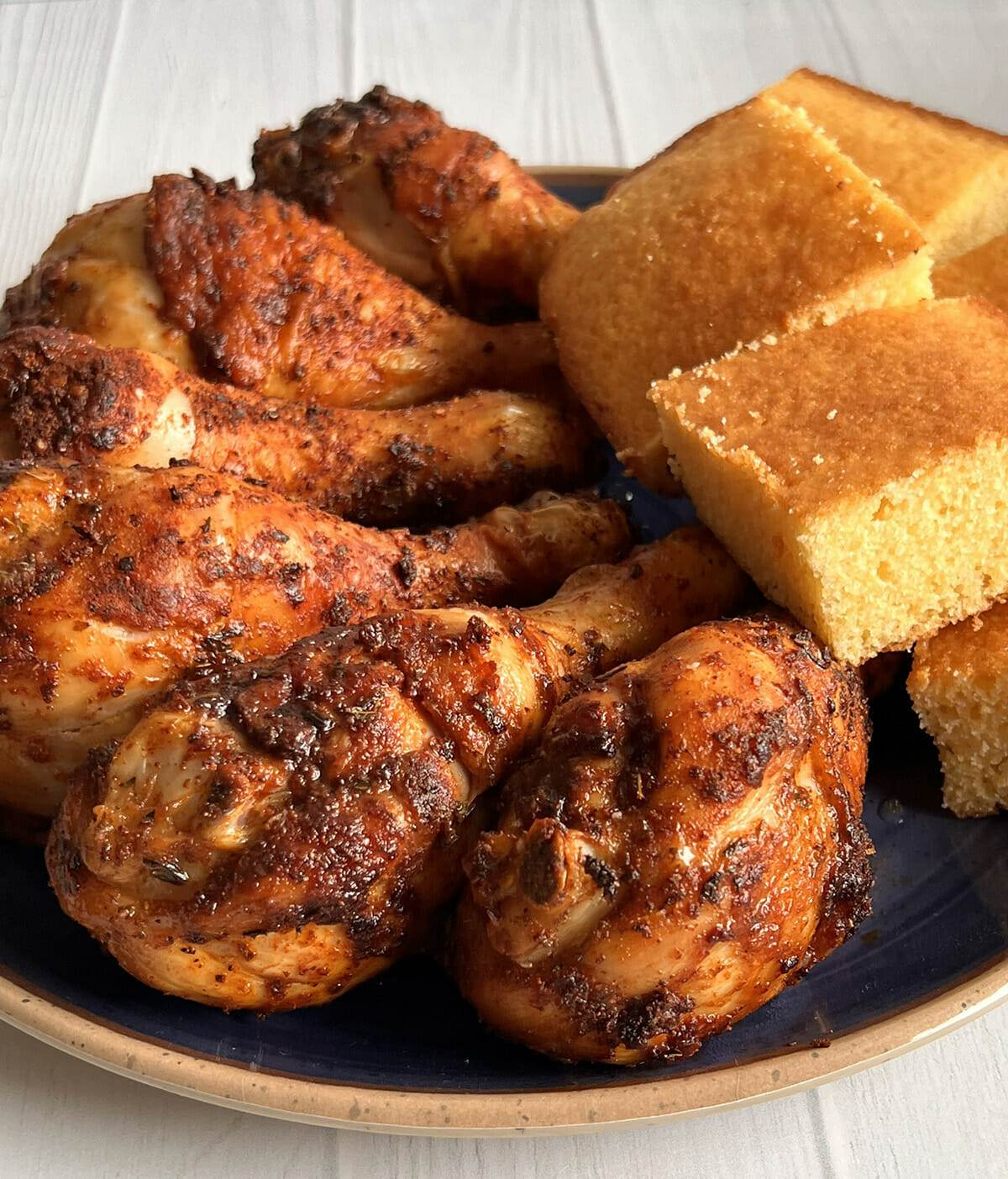 Air fryer blackened chicken drumsticks served with cornbread.