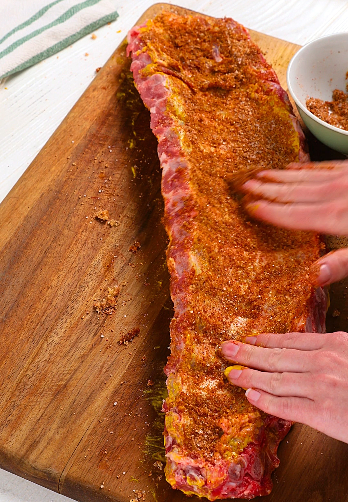 Seasoning baby back ribs to be made in the oven.