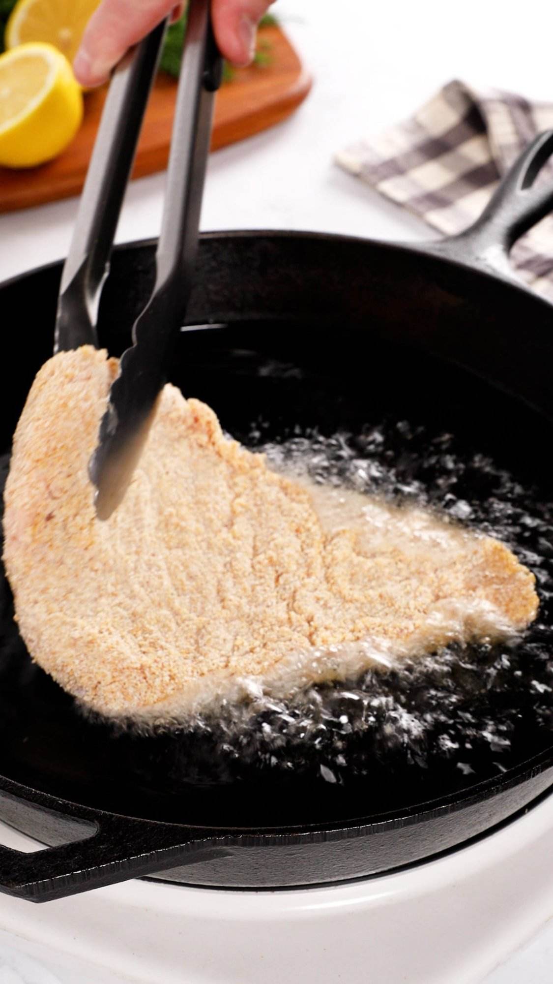 Pan frying pork schnitzel.