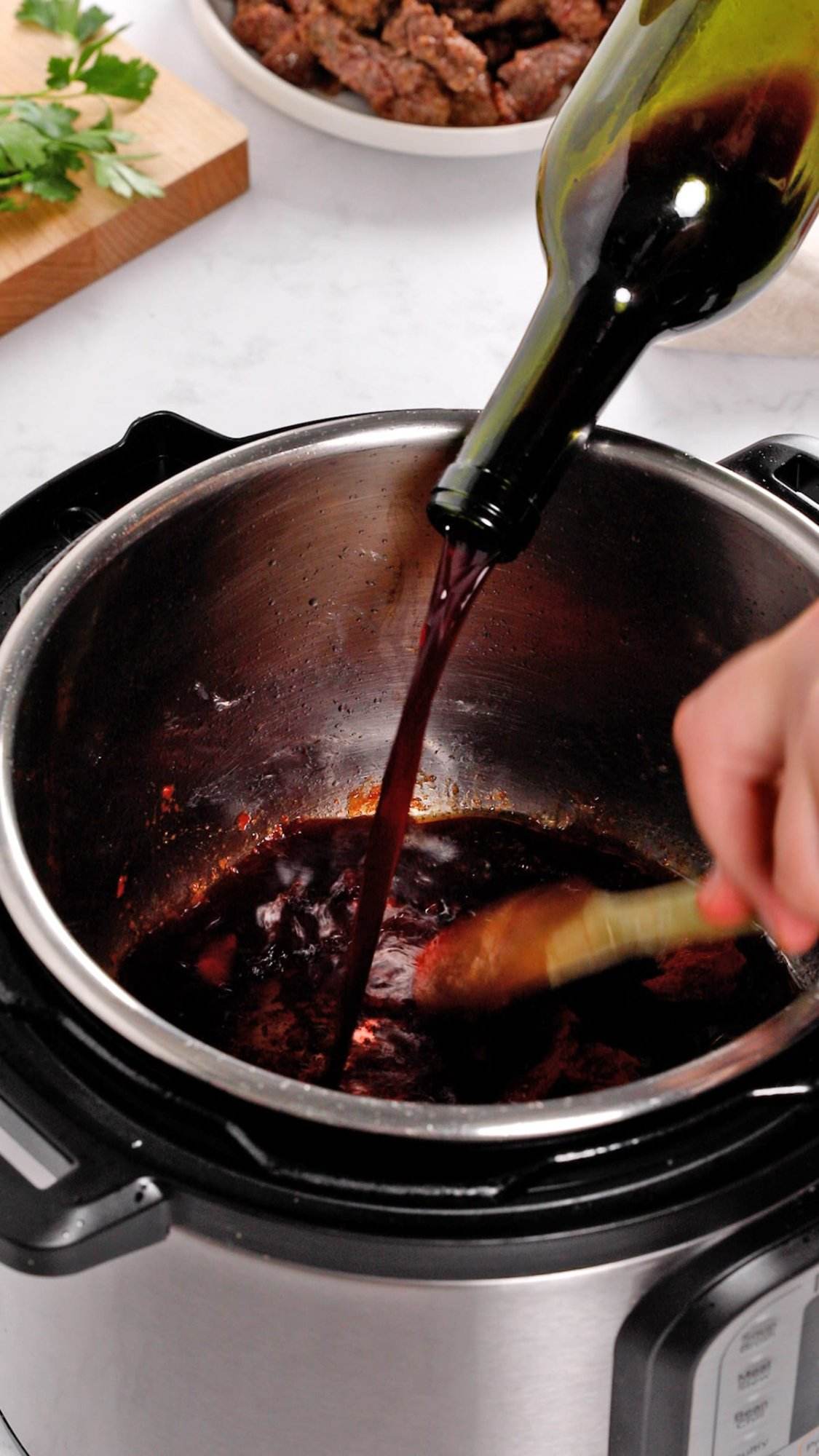 Deglazing the bottom of the Instant Pot while making beef stew recipe.