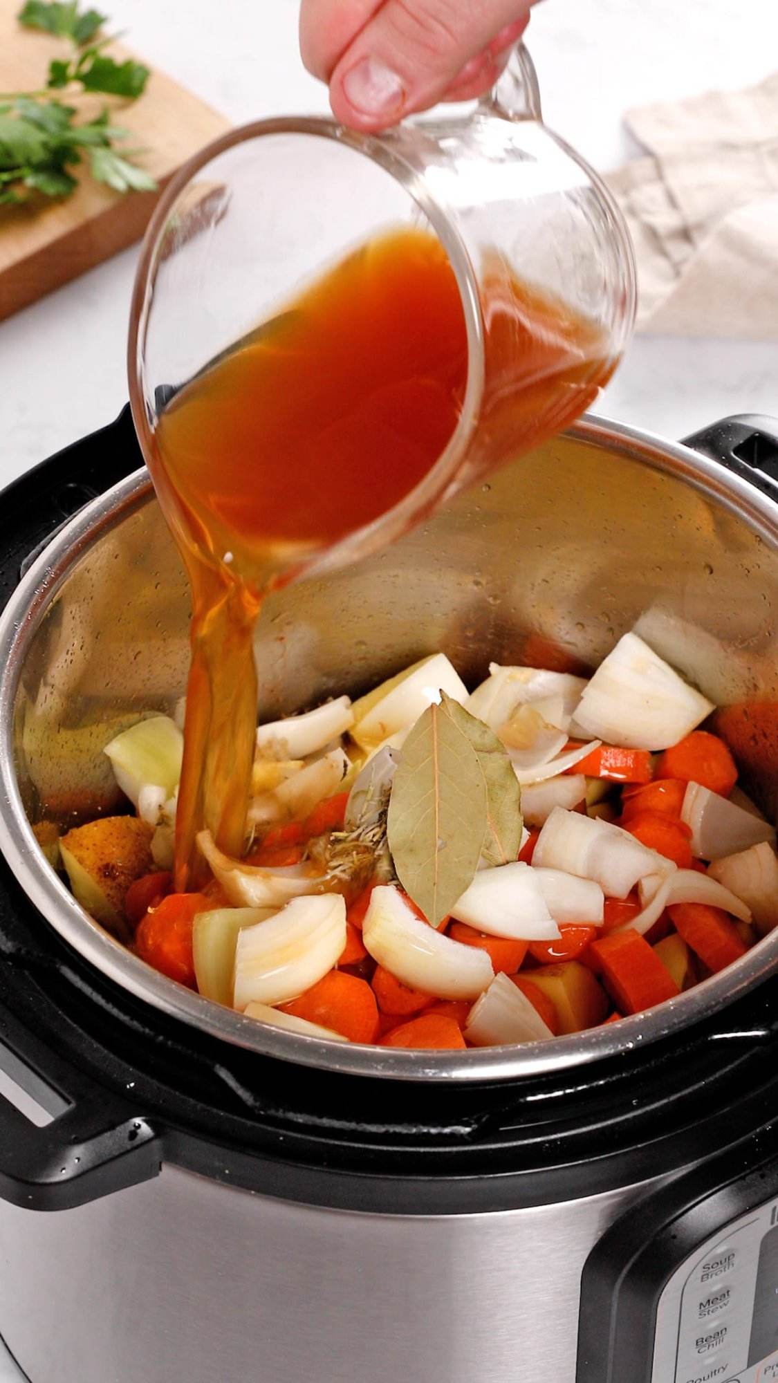 Adding all the ingredients to an Instant Pot to make beef stew.