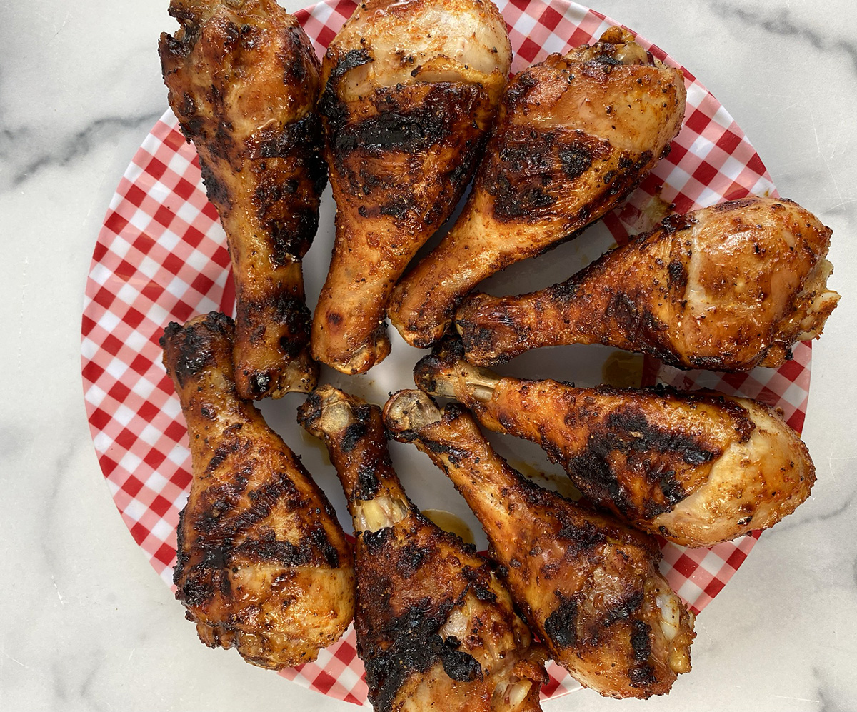 Grilled chicken legs resting on a platter.
