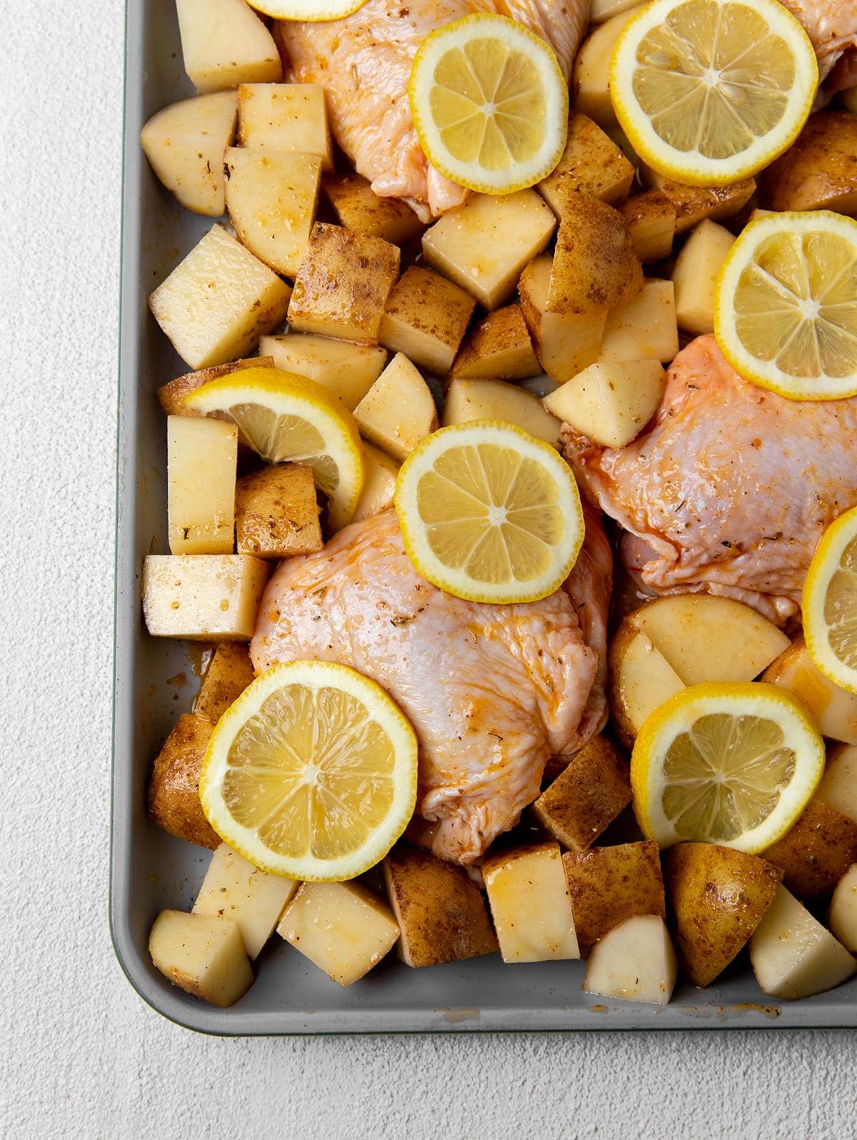 Sheet pan lemon chicken thighs and potatoes ready to go into the oven.