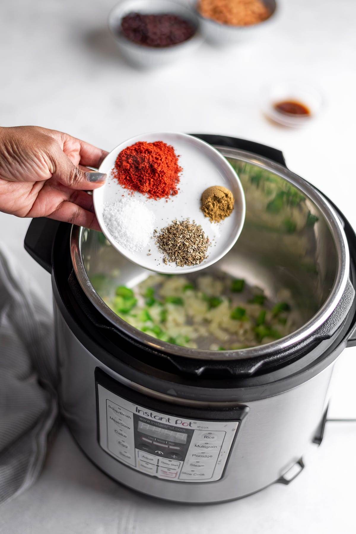 Adding ingredients to make Instant Pot vegetarian chili.