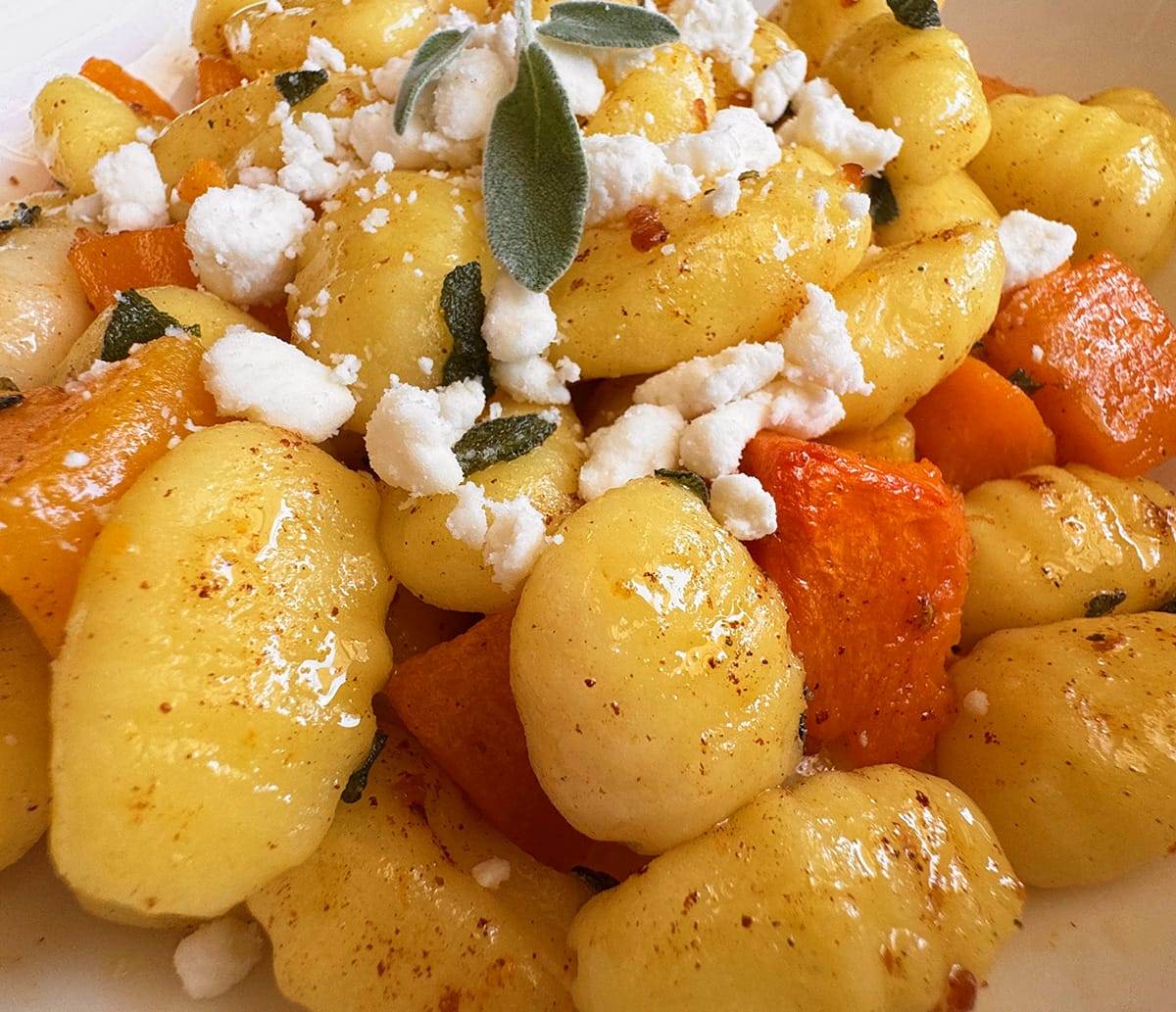 Cooked gnocchi with roasted butternut squash topped with a brown butter sage sauce and goat cheese crumbles.