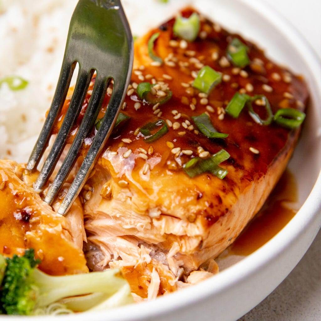 Air fryer teriyaki salmon served in a bowl with rice and broccoli.