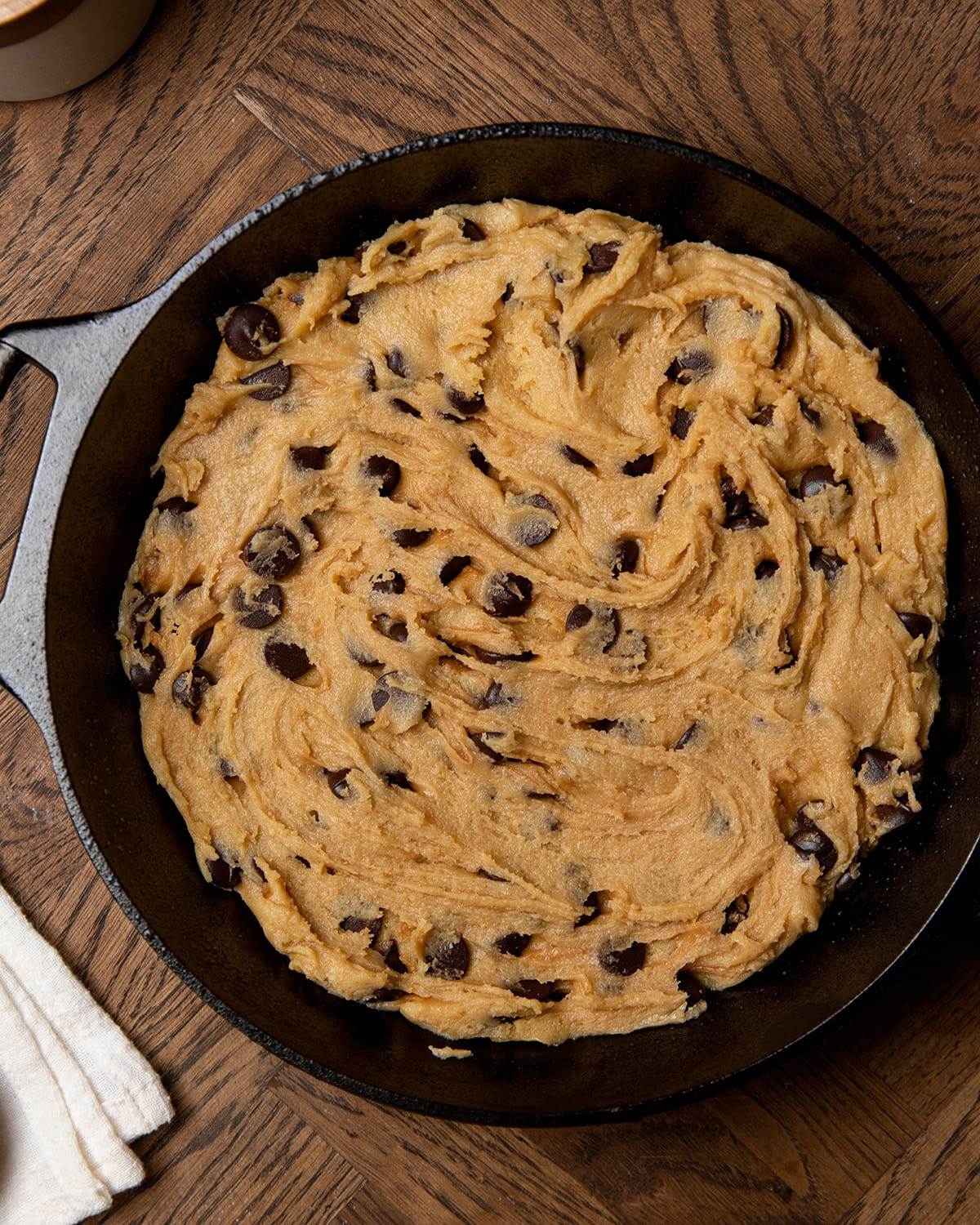 Chocolate chip cookie dough in a skillet ready to bake.