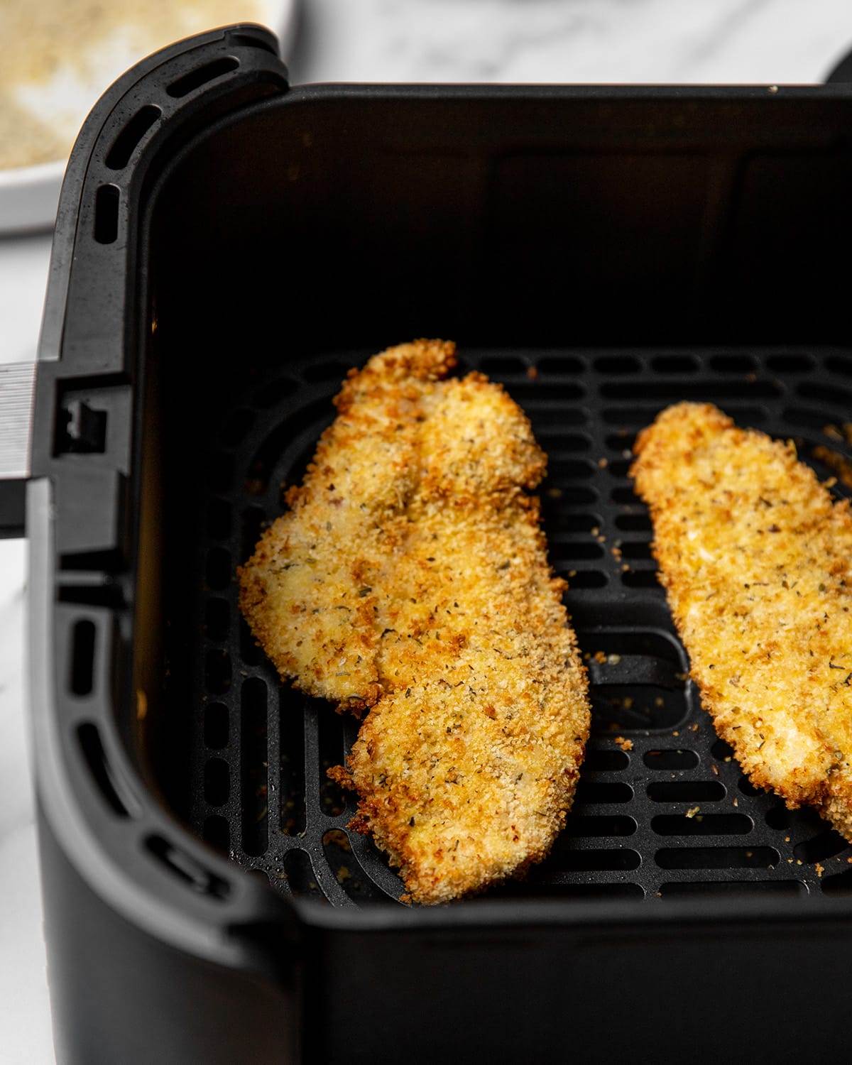 Breaded chicken breasts to make chicken parmesan are cooked to perfection in an air fryer.