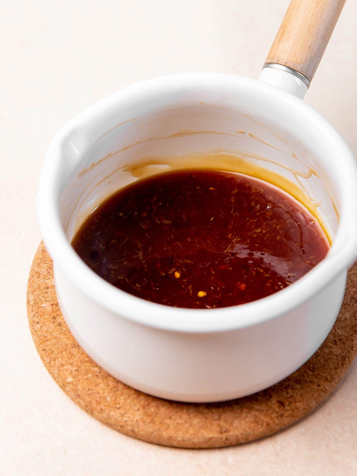 A saucepan with honey garlic wing sauce.