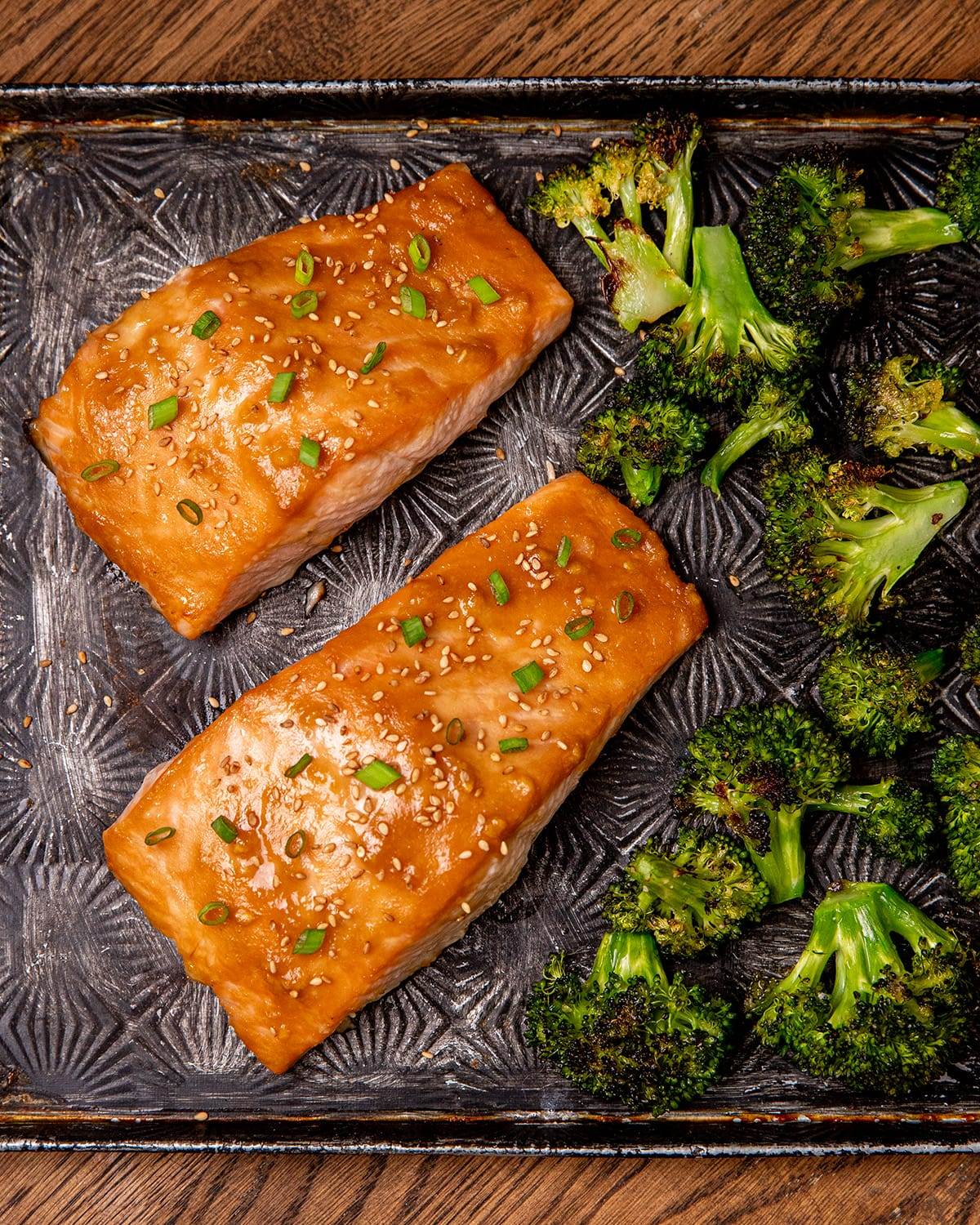 A sheet pan with cooked miso salmon and broccoli.