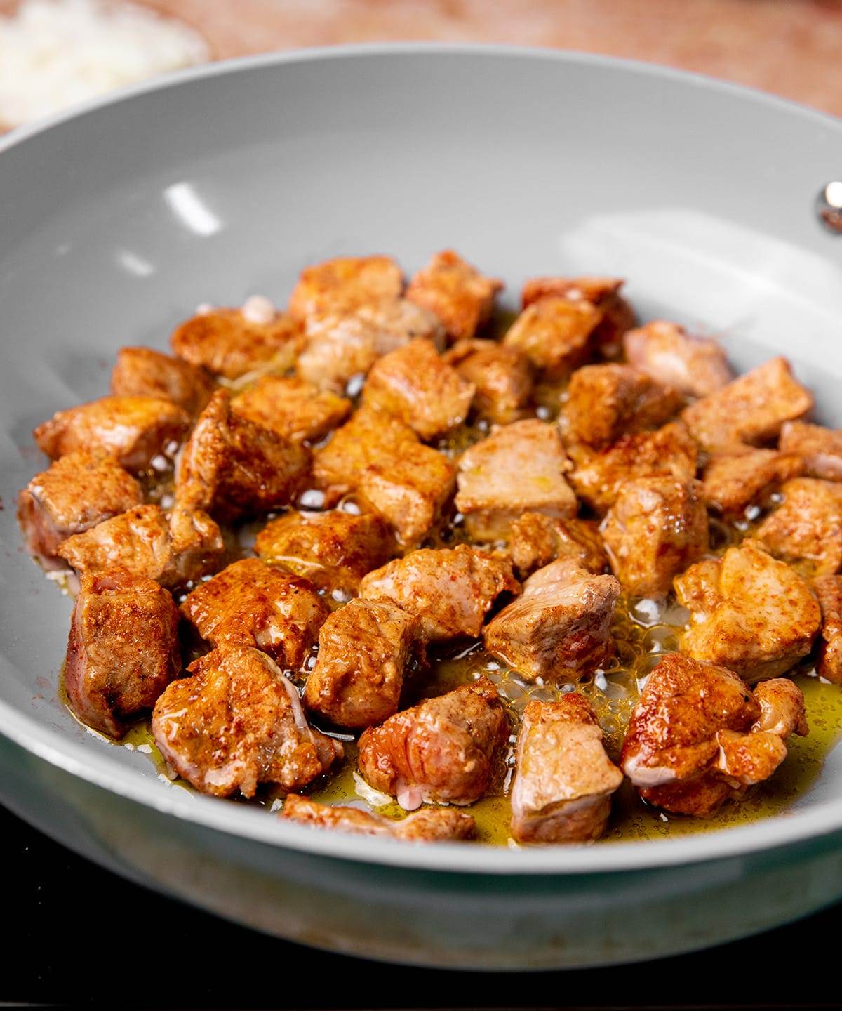 Cooking seasoned pork for pork tacos.