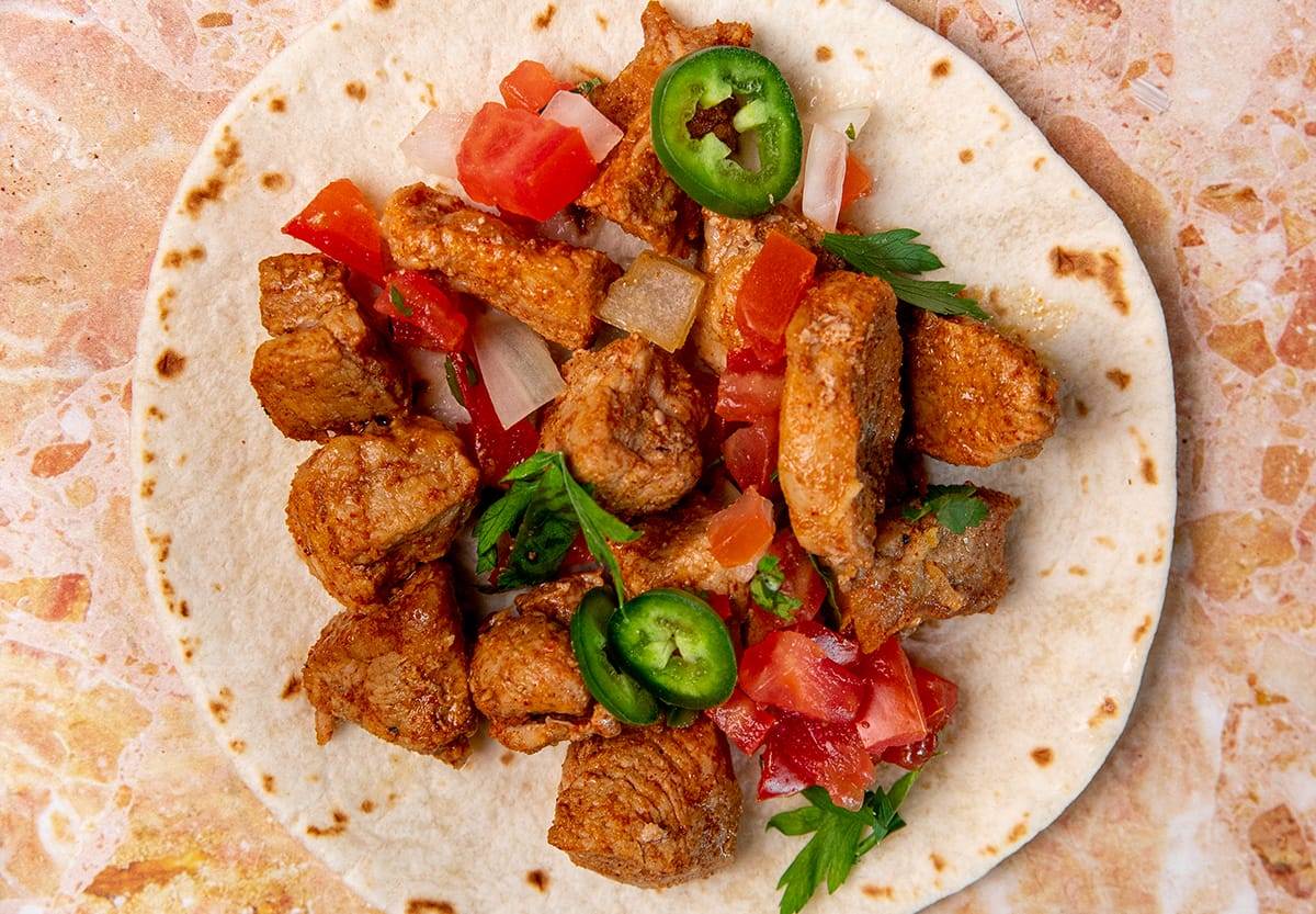 Loading up a tortilla with our pork taco ingredients!