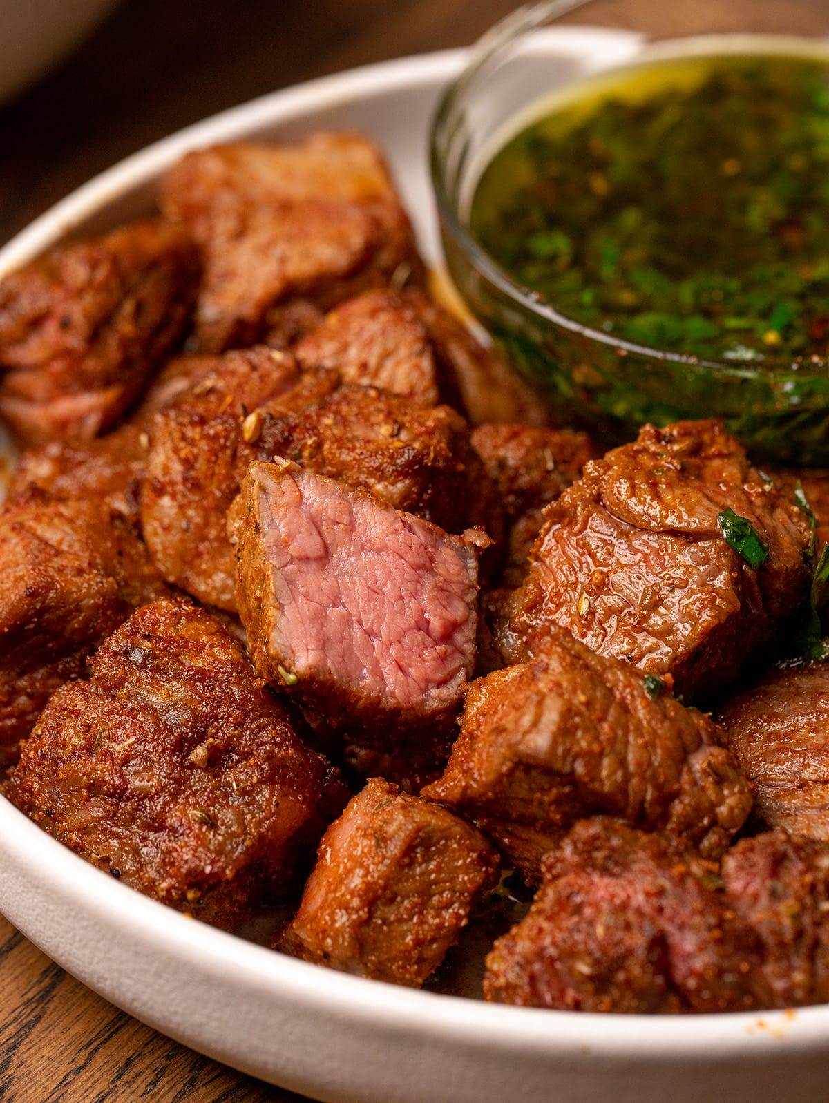 Air fryer steak bites with a chimichurri sauce.