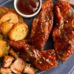 Country-style pork ribs served with potatoes and BBQ sauce.