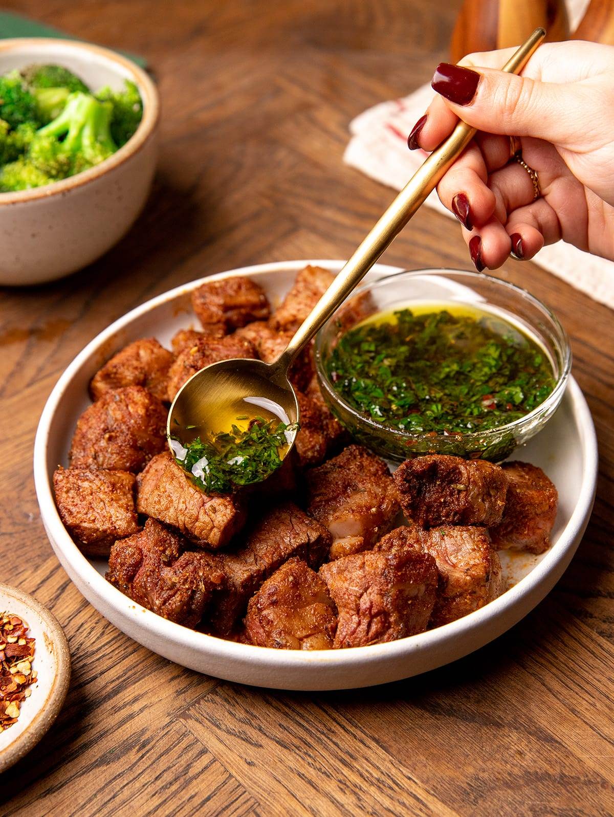 Serving air fryer steak bites with chimichurri sauce.