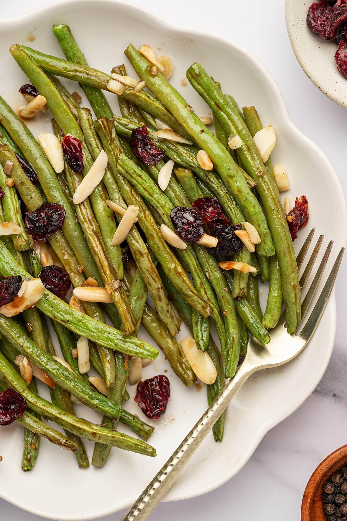 A plate of sweet, tangy, and full of flavor baked green beans with cranberries and almonds.