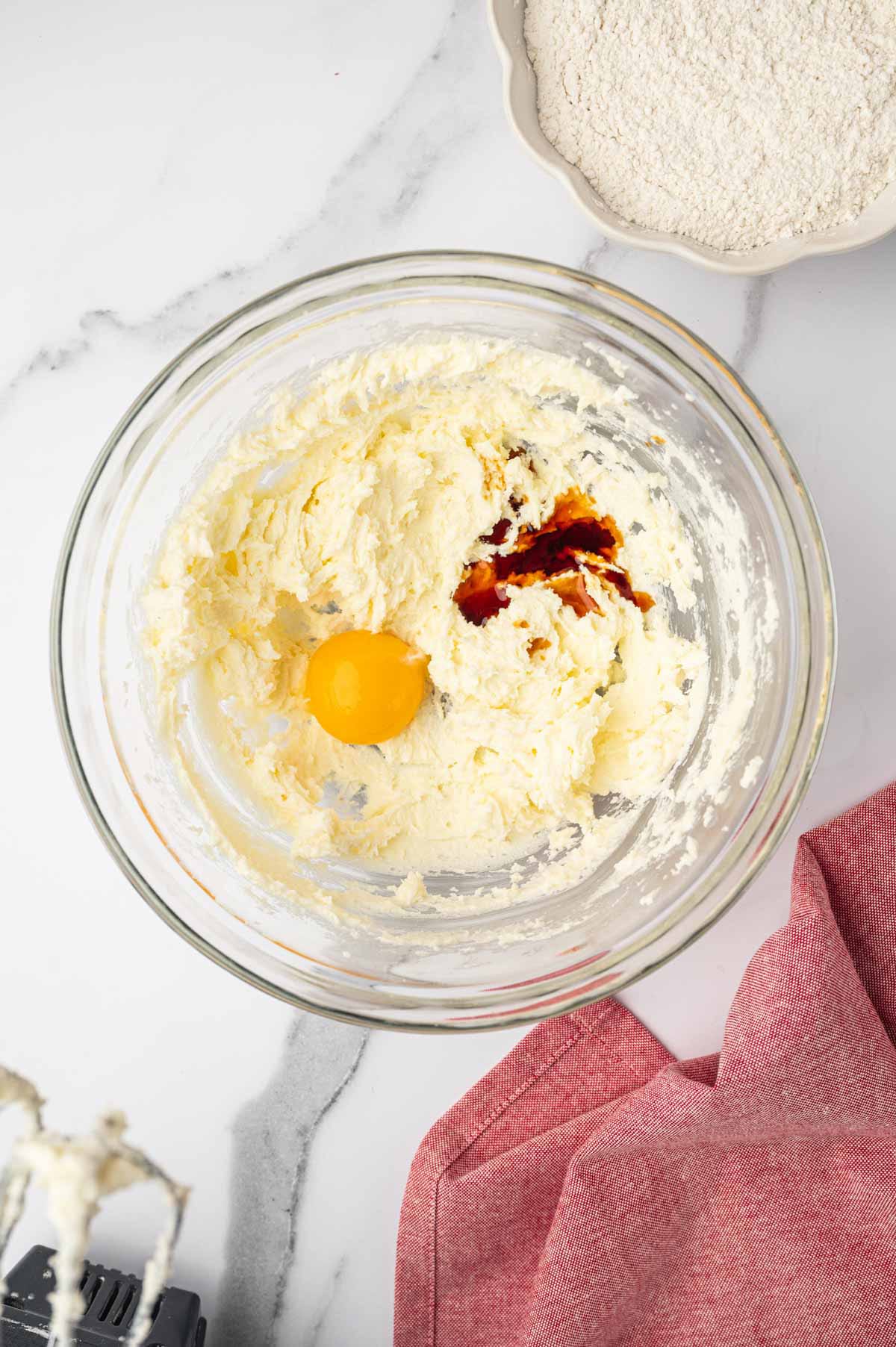 Mixing the cookie dough in a glass bowl for heart-shaped sugar cookies.