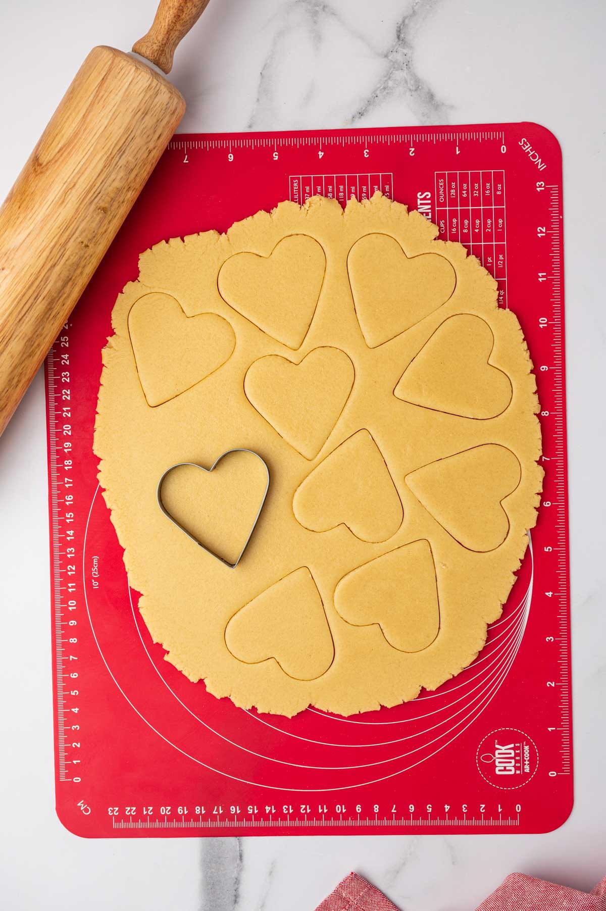 Cutting out heart-shaped sugar cookies with a cookie cutter.