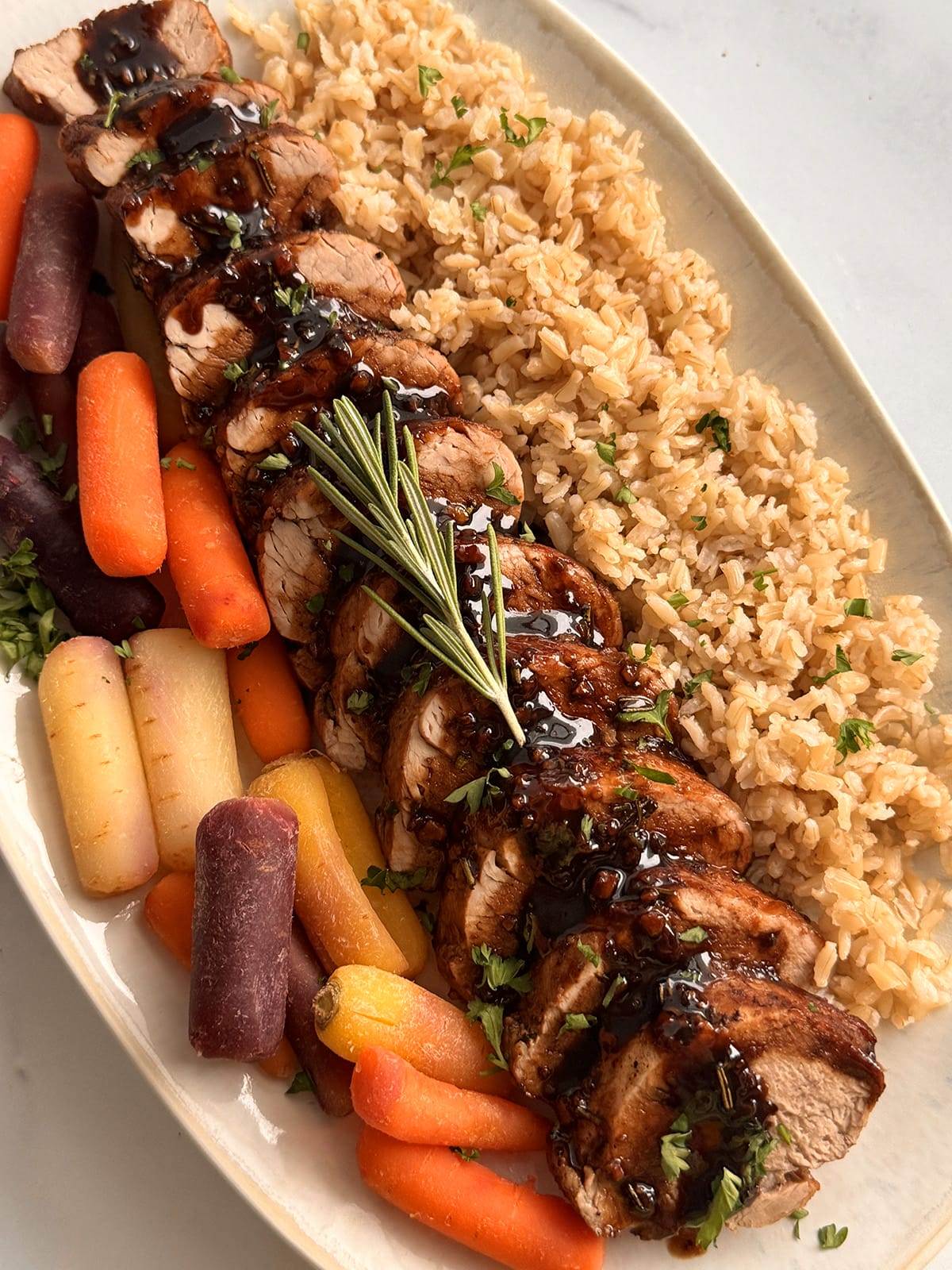 Balsamic pork tenderloin served with carrots and brown rice.
