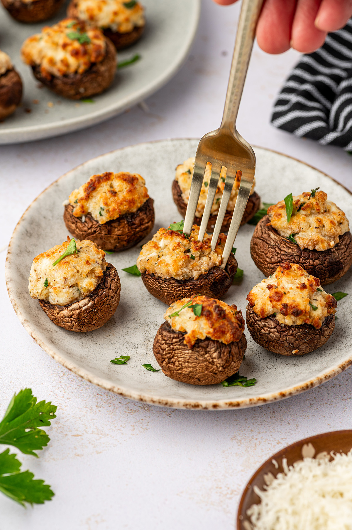 Air fryer stuffed mushrooms on a white plate with a fork.