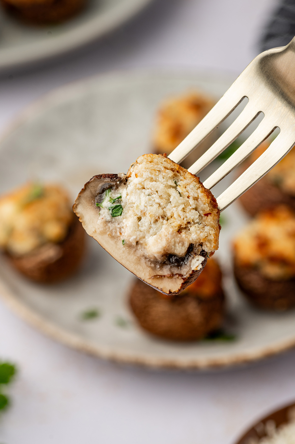 An air fryer stuffed mushroom on a fork.