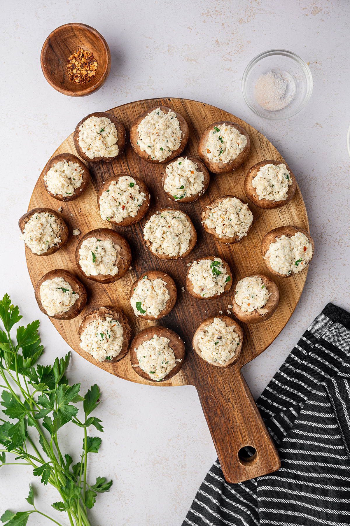 Stuffed mushrooms on a wooden cutting board.